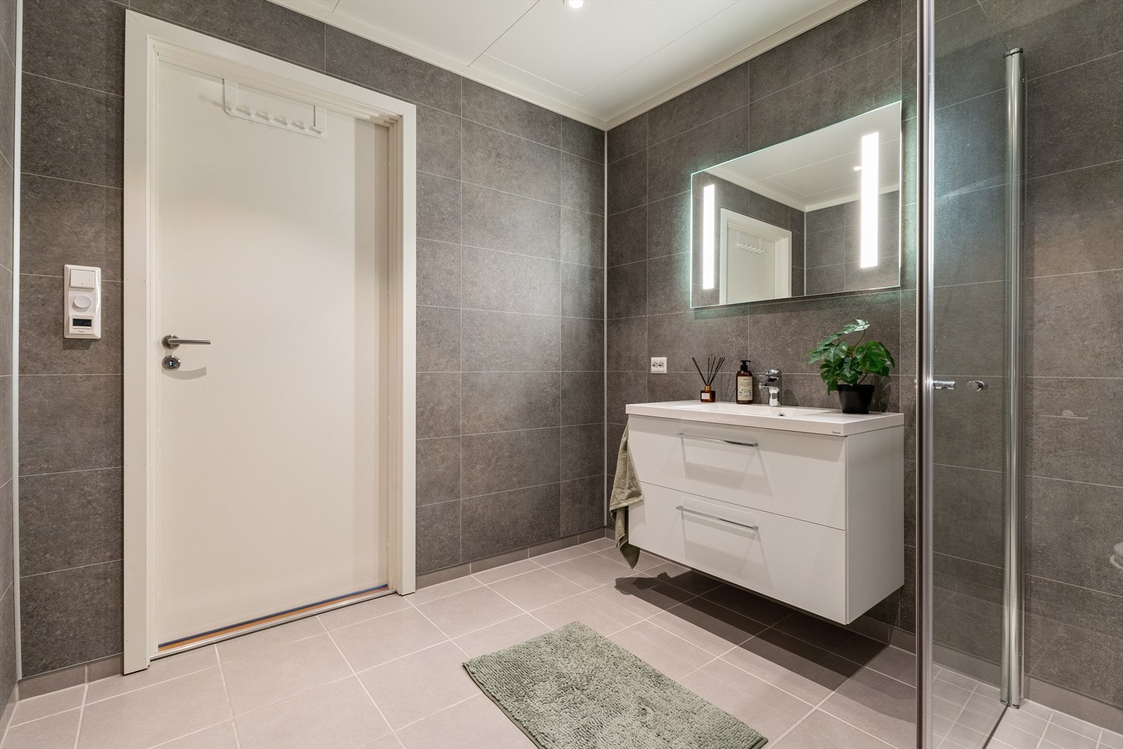 Det er flislagt gulv og våtromsplater på veggene. Galleribilde