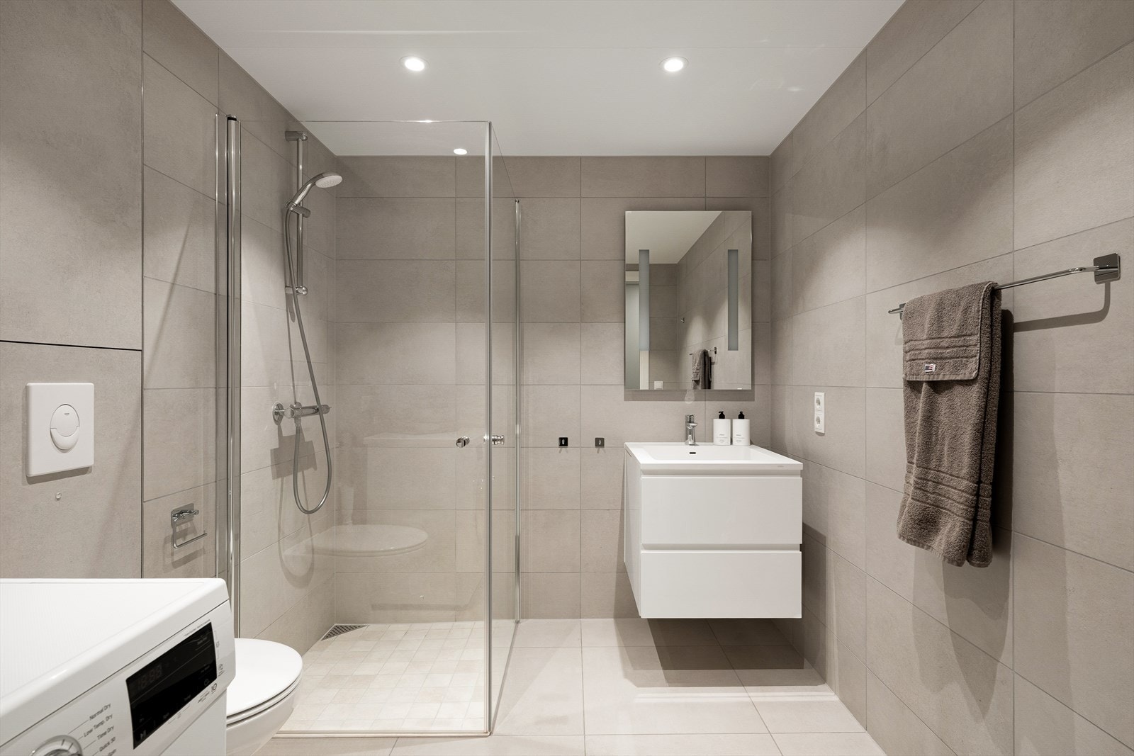 Pent, flislagt baderom med downlights i tak og vannbåren gulvvarme Galleribilde