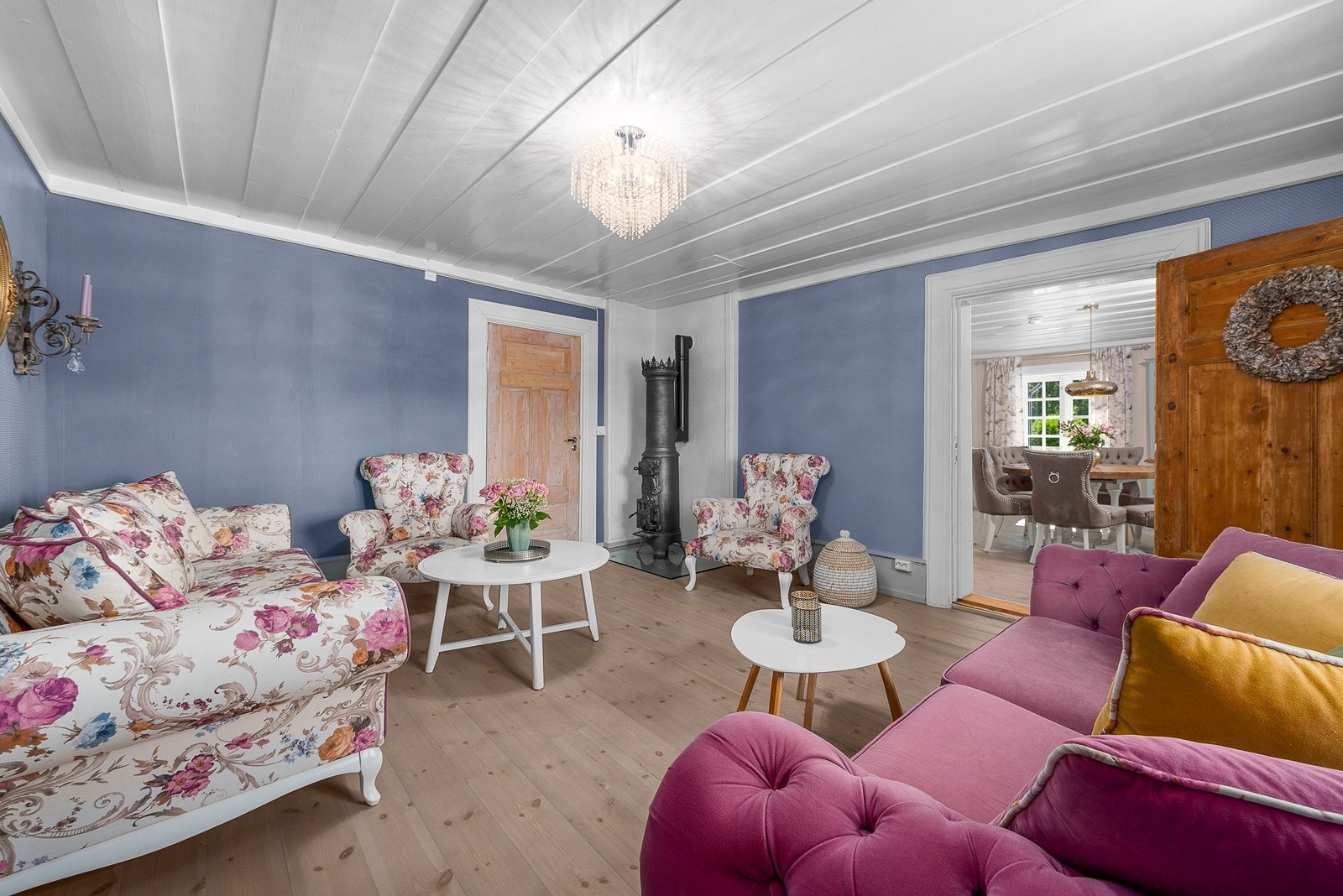 Stuen mellom kjøkkenet og storstuen har tapetserte vegger og samme gulv og himlingsflater som de andre rommene i første etasje, samt enda en lekker og historisk peisovn Galleribilde