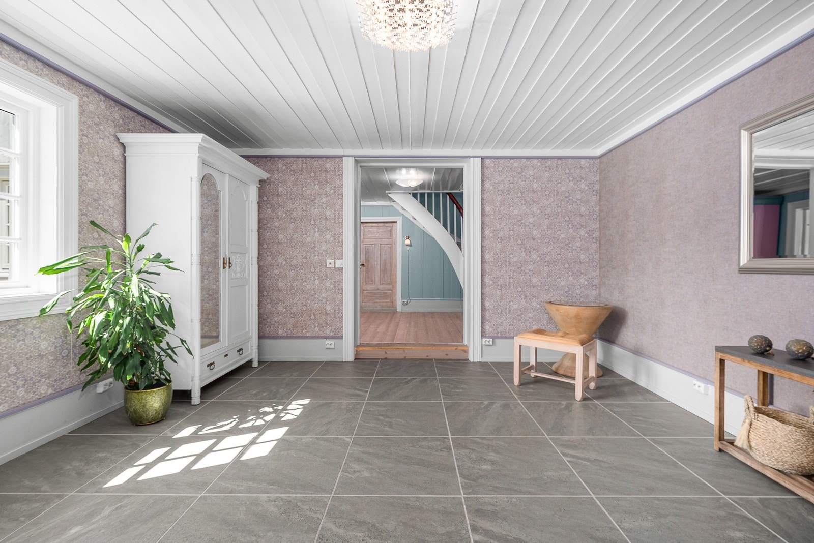 Hallen er pusset opp i selgers eiertid, og har nå stilrene store fliser som passer godt inn i boligens estetikk Galleribilde