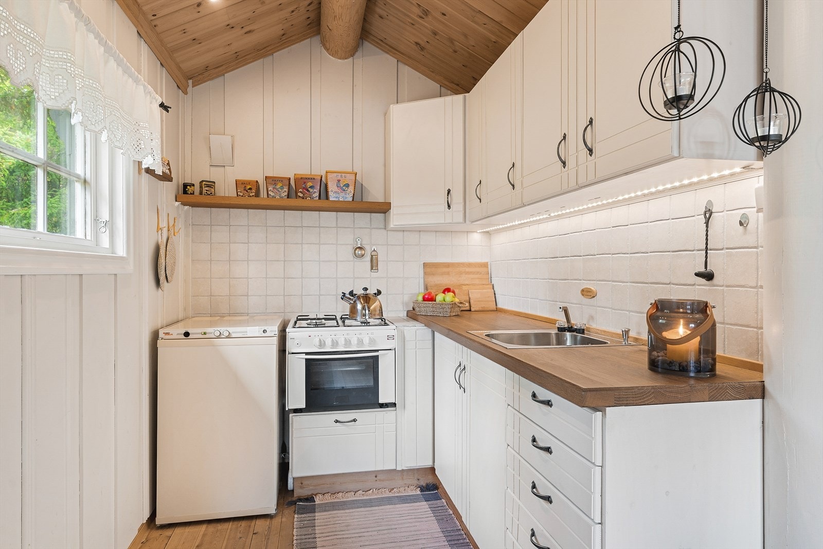 Kjøkkenkroken har lys innredning med benkeplate i heltre. Galleribilde