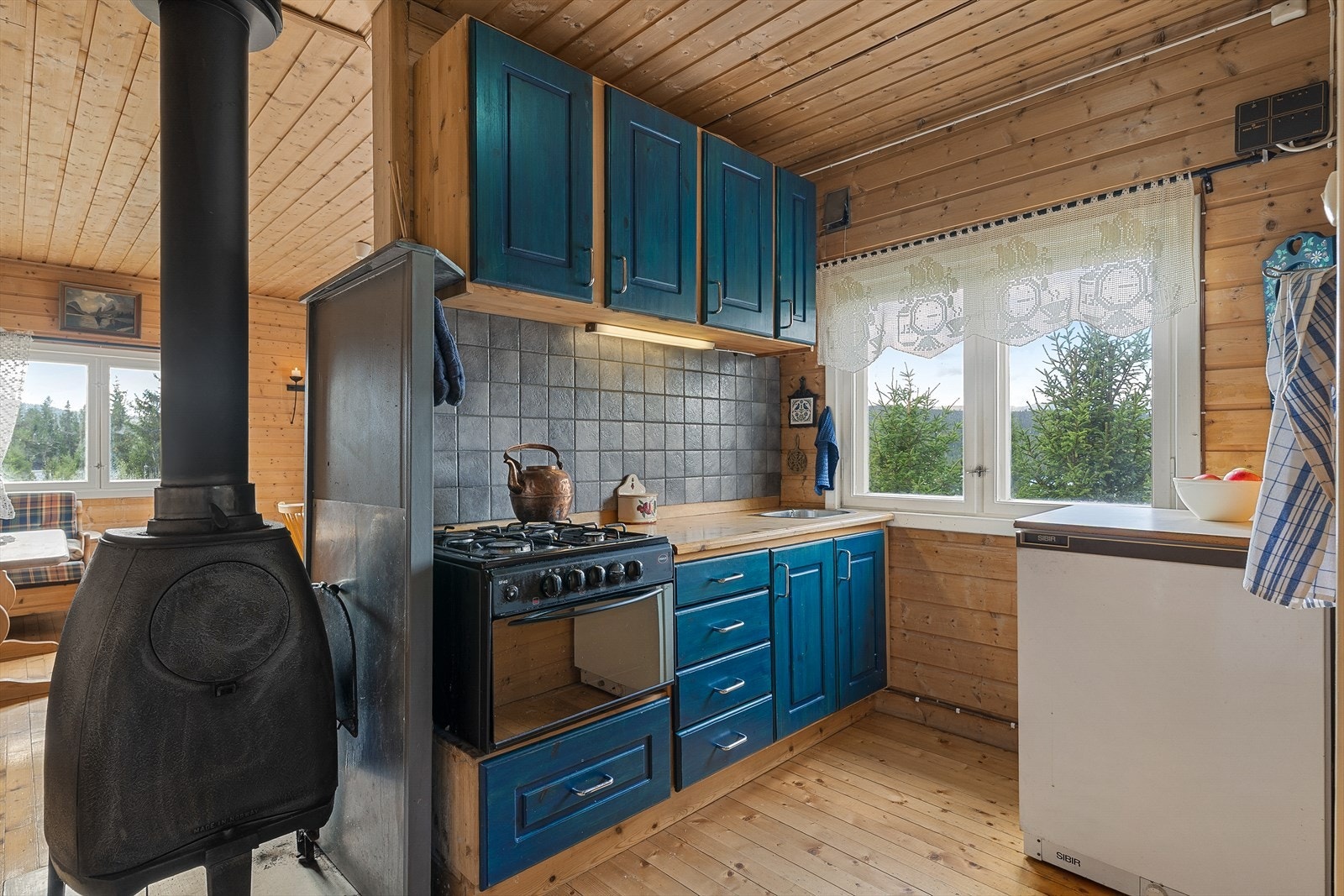 Kjøkkenet er enkelt innredet og ligger delvis skjermet fra stuen - en praktisk løsning som gir en egen sone for matlaging. Galleribilde