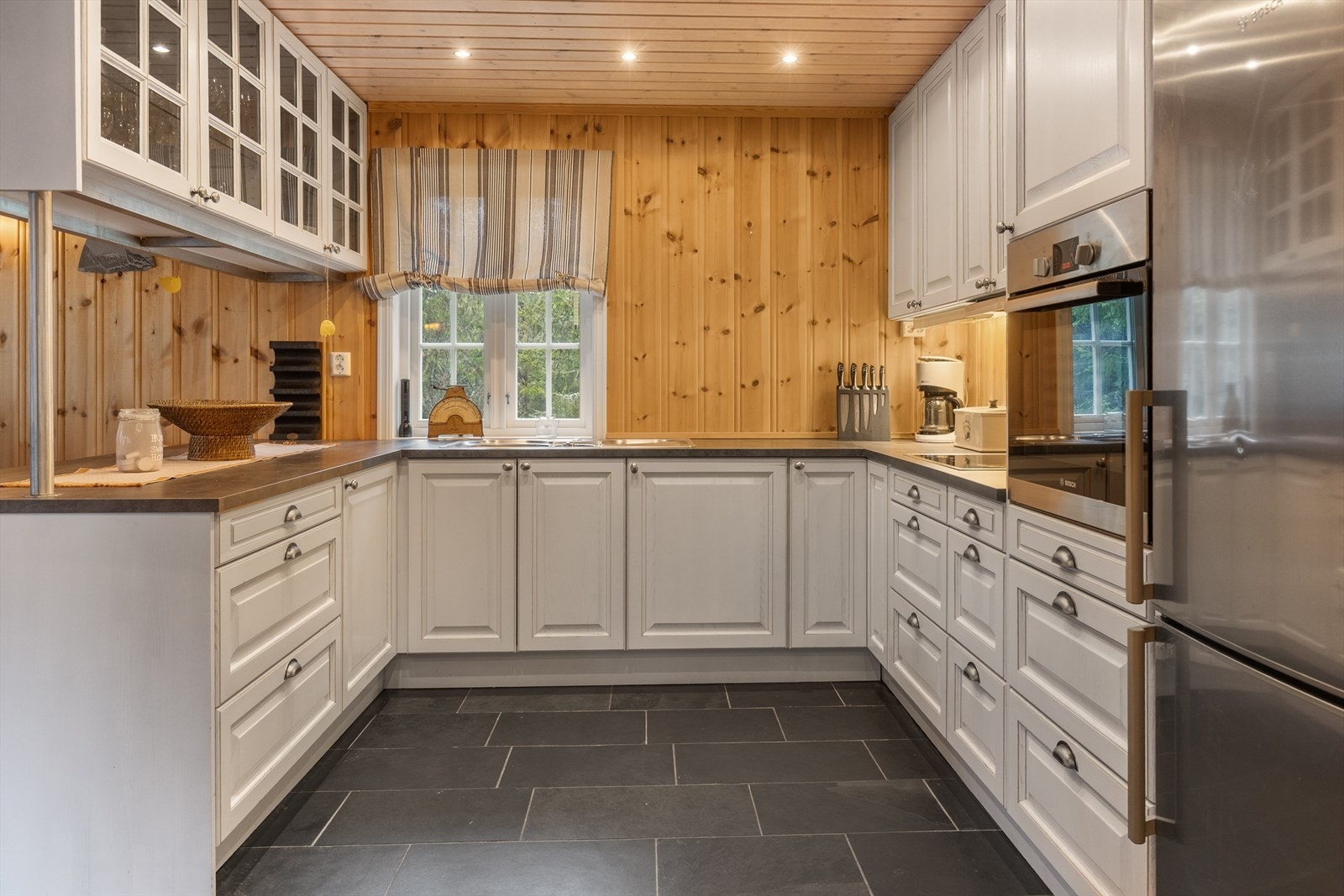 Kjøkkenet er innholdsrik med mye over- og underskap i tillegg til benkeplass Galleribilde