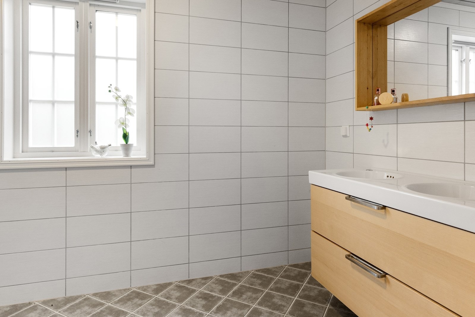 Baderomsinnredning med skuffeseksjon og vegghengt speil Galleribilde