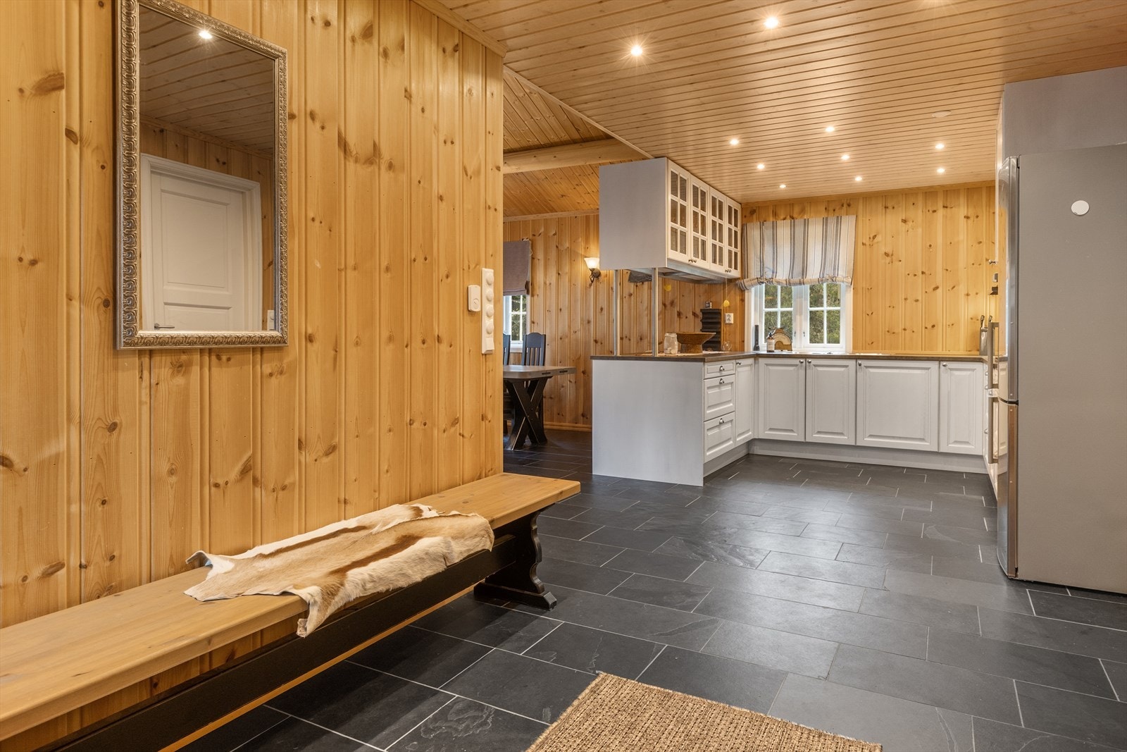 Gangen er romslig, flislagt og har plass til omkledning av yttertøy Galleribilde