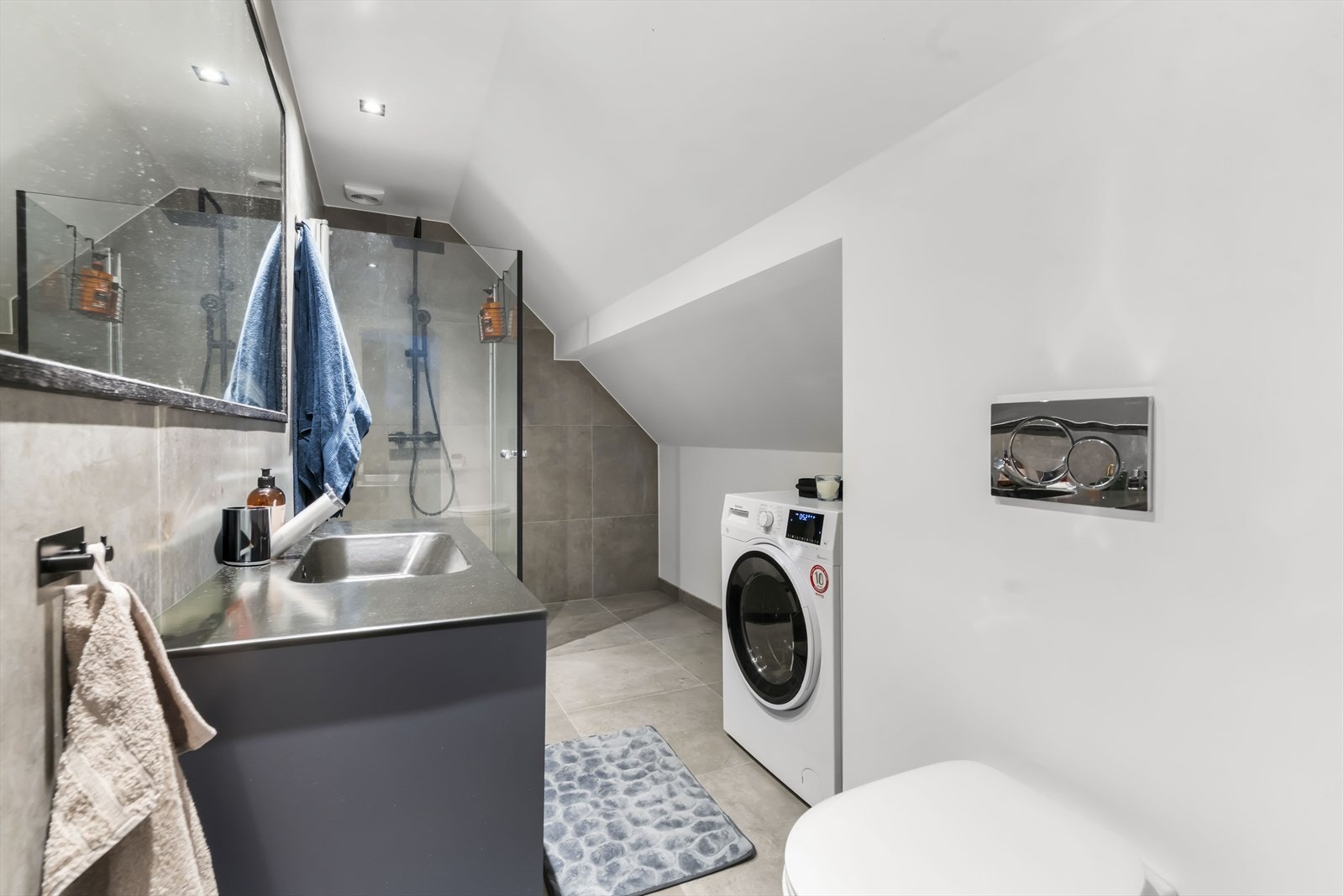 Bad i andre etasje. Badet har innredning med nedfelt servant, veggmontert toalett, dusjvegger/hjørne og opplegg for vaskemaskin. Galleribilde