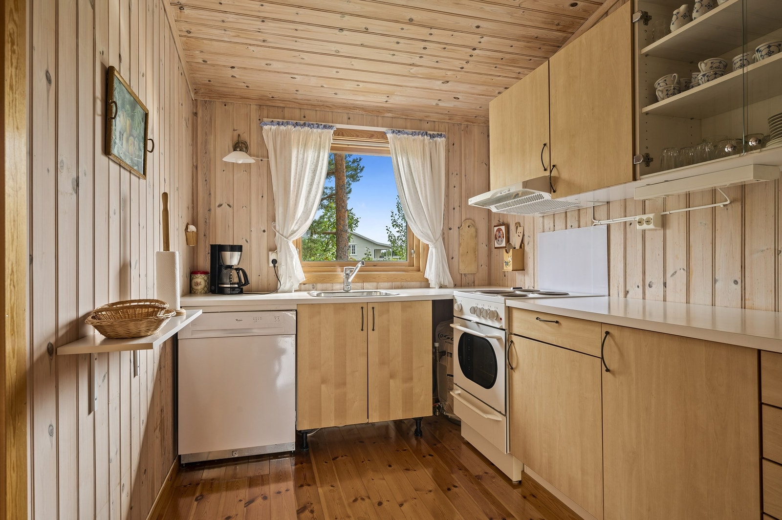 Kjøkken med kjøleskap, komfyr og oppvaskmaskin. Galleribilde