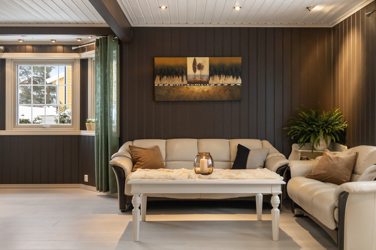 Dagslyset i stuen suppleres ypperlig av downlights i taket, og et lyst 1-stavs laminatgulv kombineres med panelvegger malt i en mørk farge Galleribilde