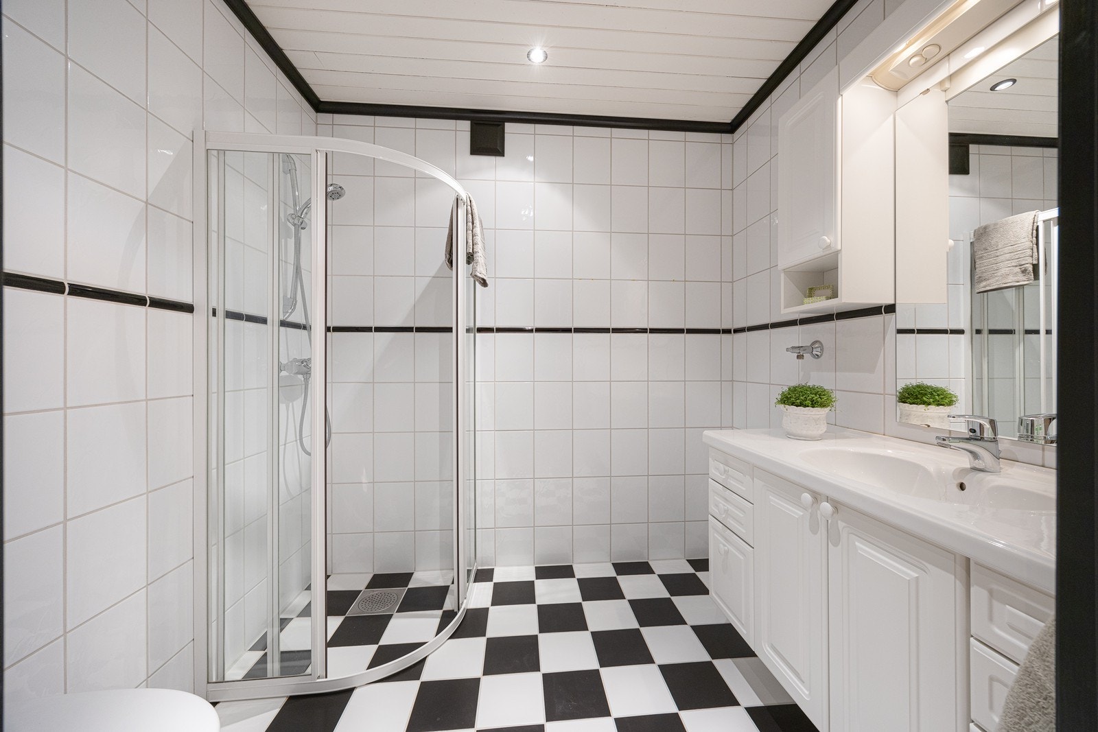 Badet i kjelleren har varmekabler, downlights, dusjhjørne, vegghengt toalett, opplegg for vaskemaskin og rikelig med oppbevaringsplass i innredningen Galleribilde