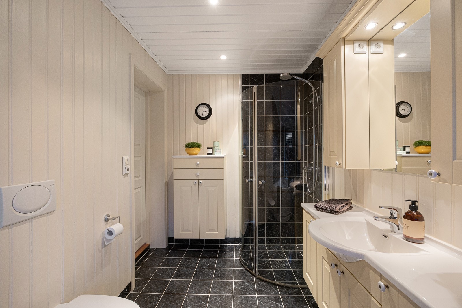 Varme er lagt i gulvet, og badet har downlights og vegghengt toalett. Skapene gir god plass til oppbevaring av håndklær og hygieneartikler Galleribilde