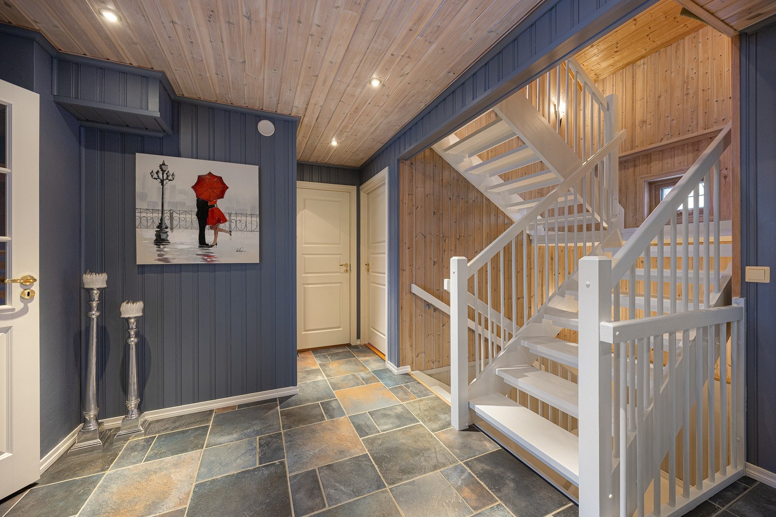 Hallen har downlights, gjestetoalett og panelvegger malt i en nydelig blåfarge Galleribilde