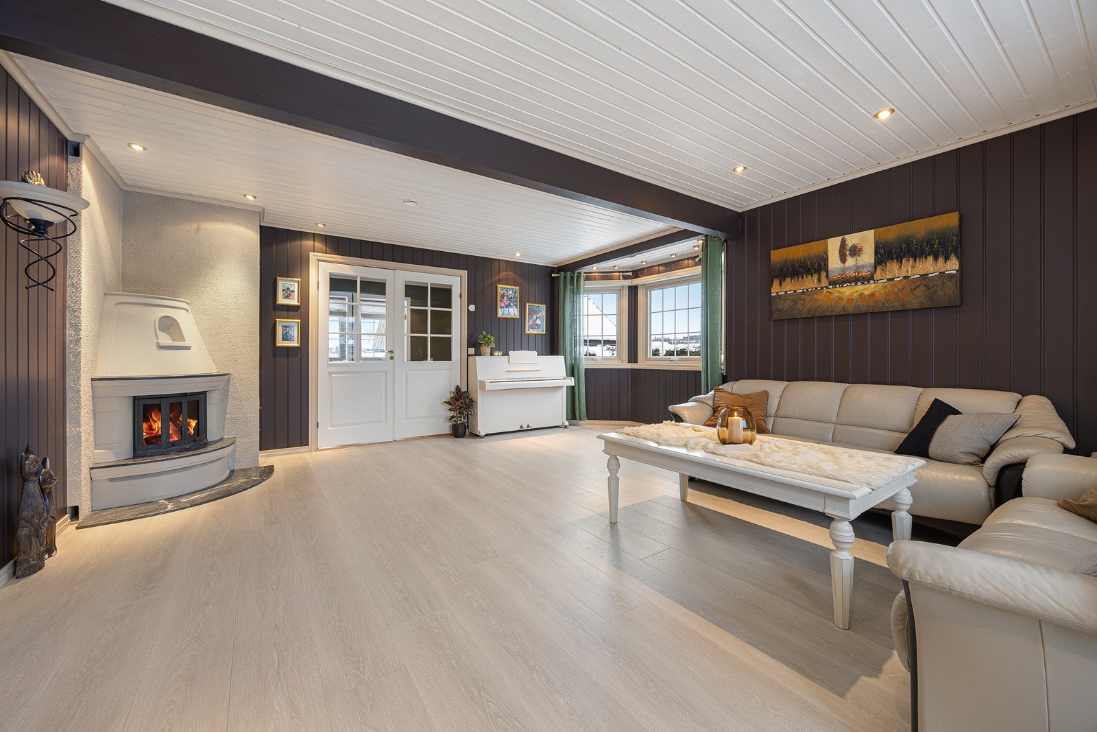 Hovedstuen er et åpent, men lunt og intimt oppholdsrom med koselig hjørnepeis Galleribilde