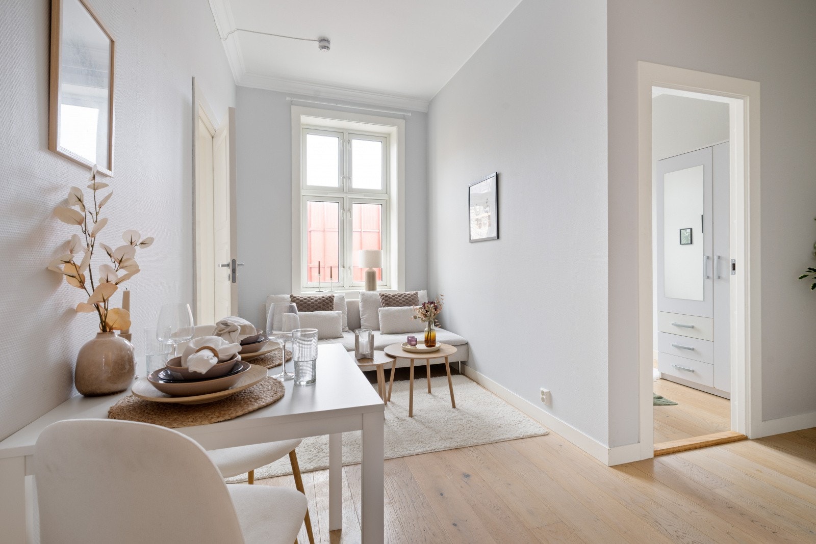 Lys stue med store vindusflater og plass til sofagruppe og spisebord. Galleribilde