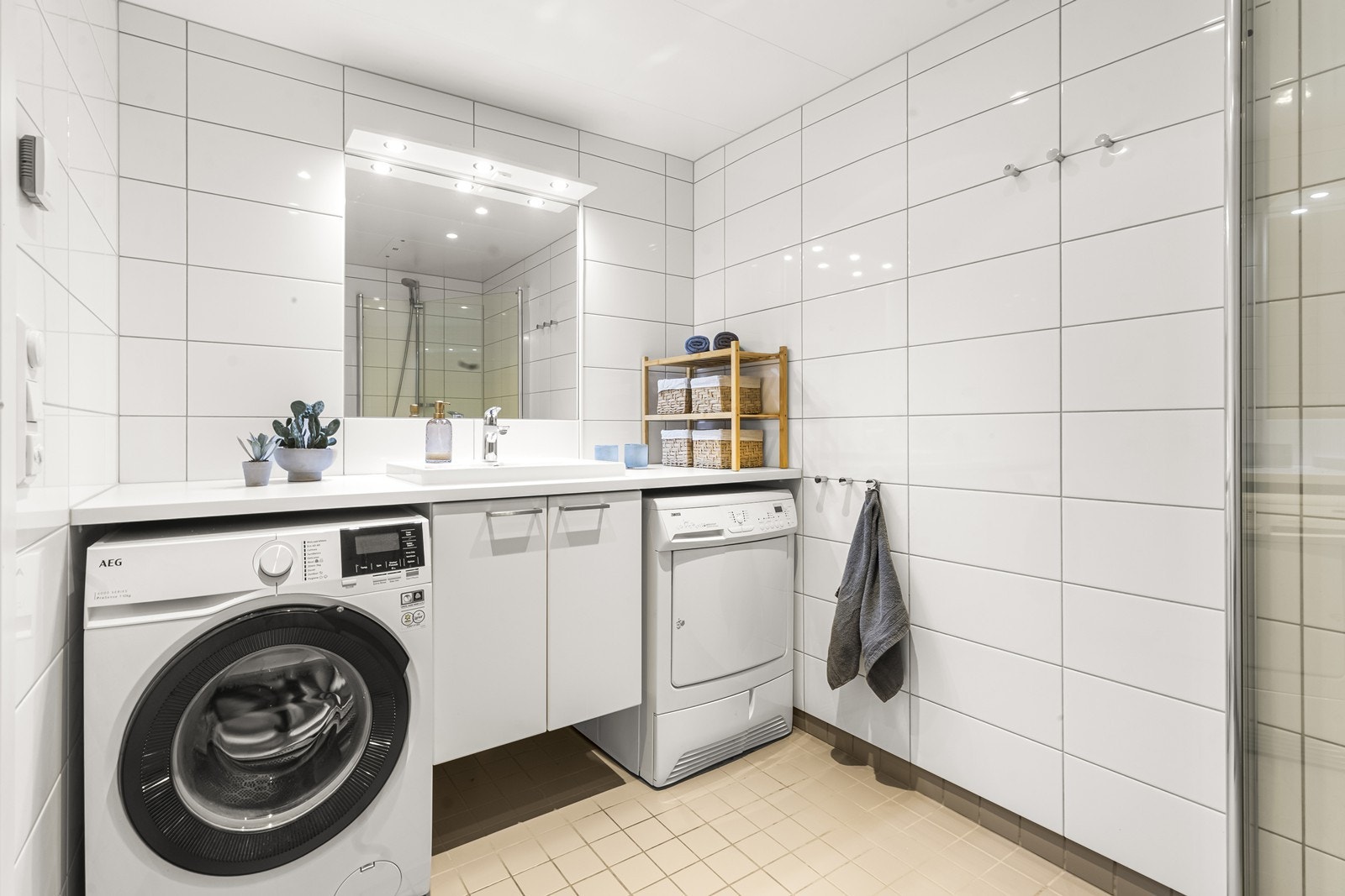 Badet er utstyrt med vegghengt toalett, servant med skap og dusjnisje med innfellbare glassdører. Galleribilde