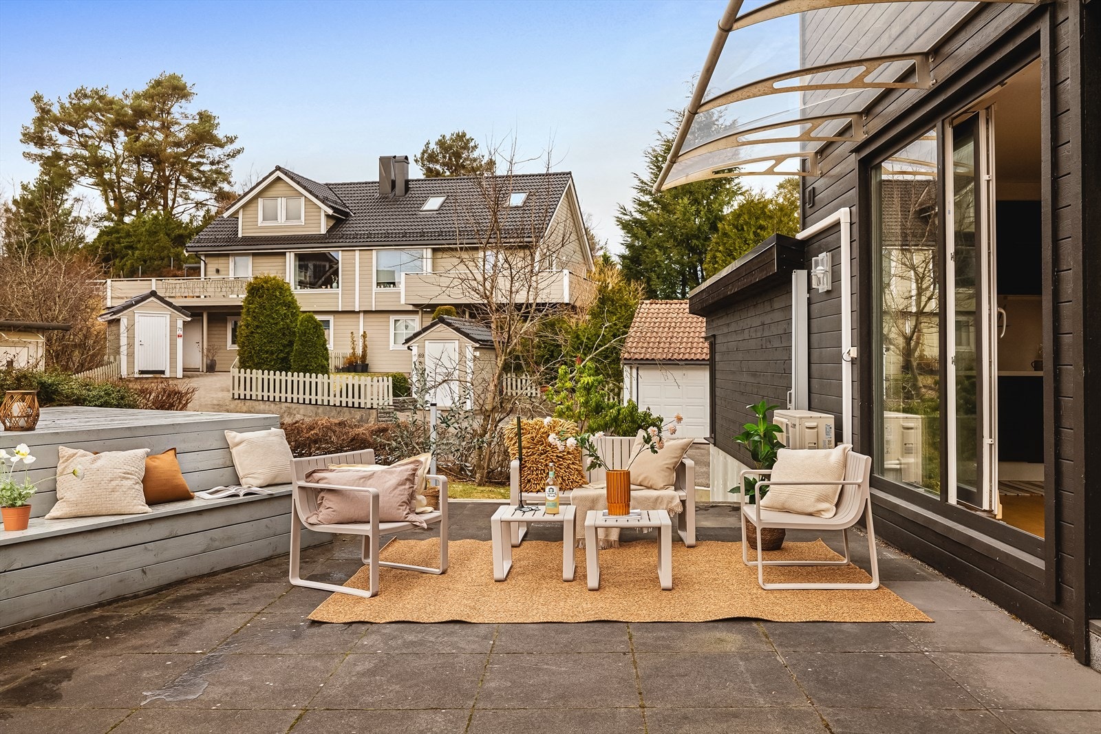 Området rundt boligen er pent opparbeidet med grøntarealer og asfaltert adkomst, og gir gode muligheter for å innrede med ønskede utemøbler Galleribilde