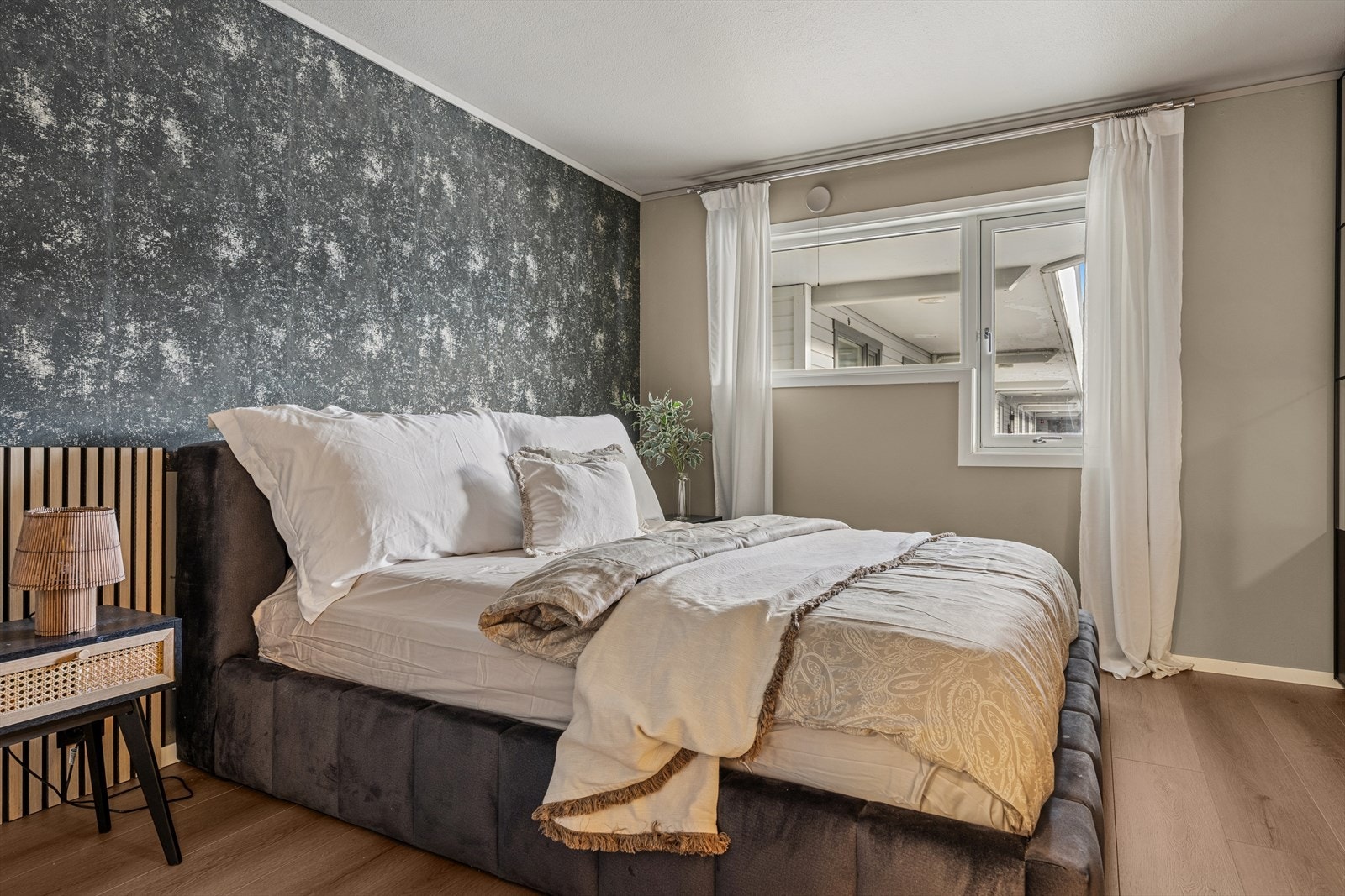 Leilighetens soverom med plass til stor seng og nattbord. Galleribilde