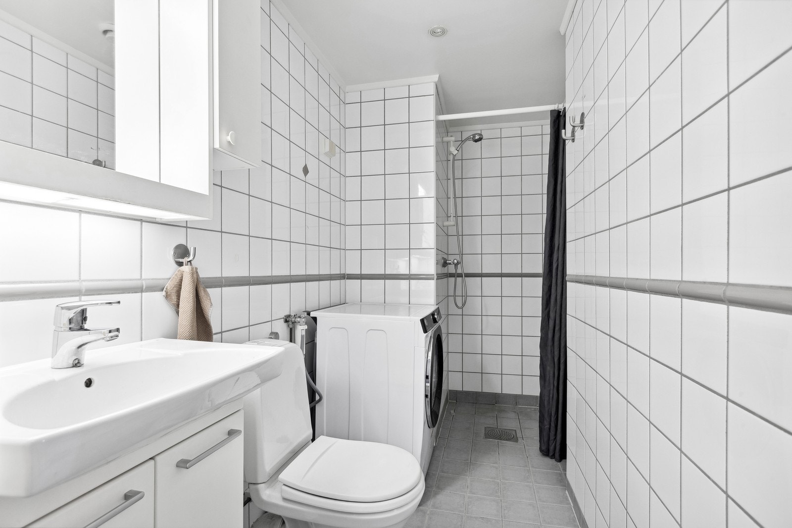 Flislagt baderom med opplegg for vaskemaskin. Galleribilde