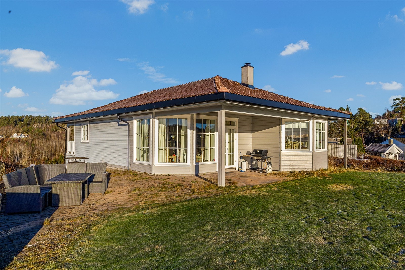 Uteplassen er pent opparbeidet med belegningsstein og tilliggende gressplen. Galleribilde