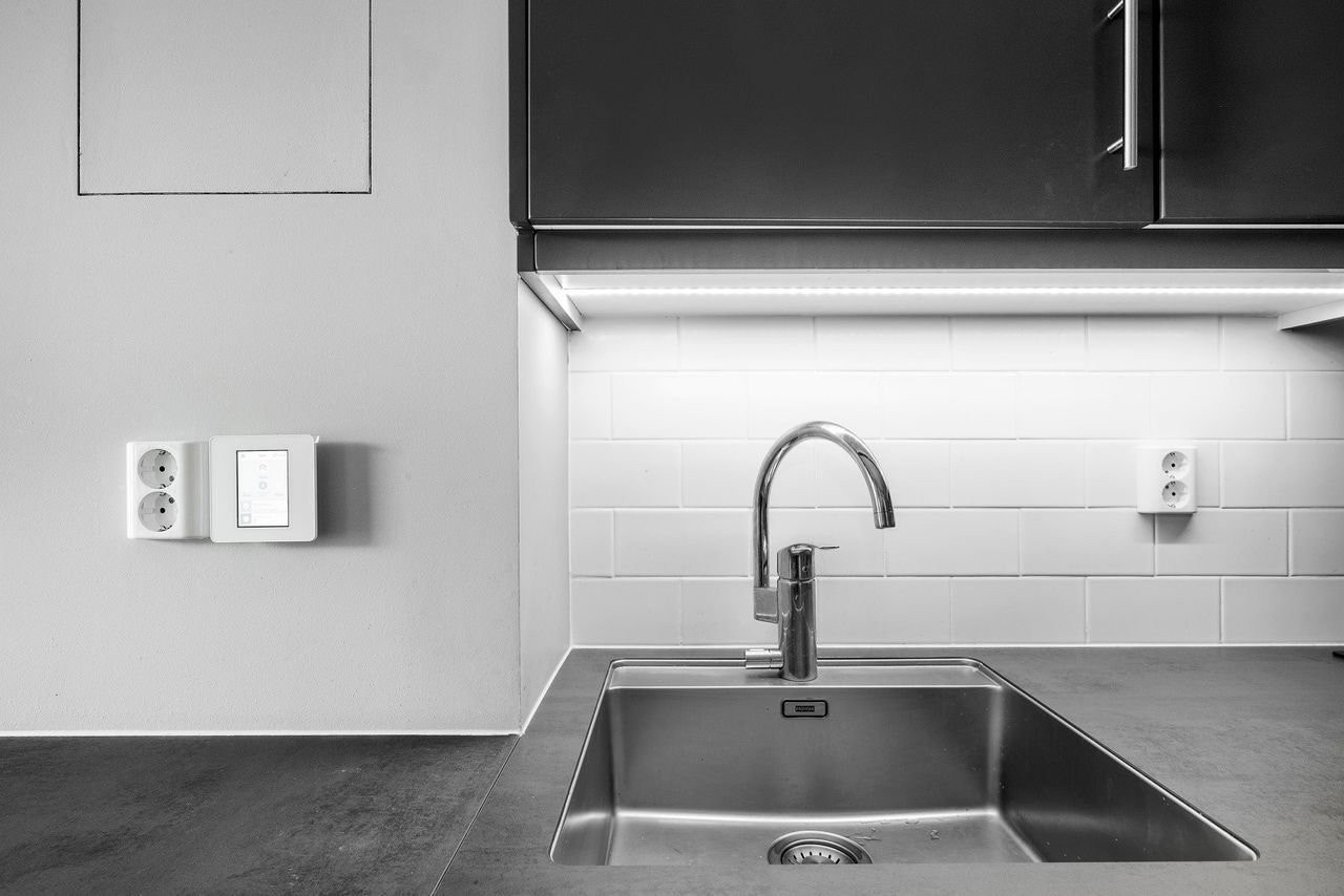 Kjøkkenvask med moderne armatur og integrert oppvaskmaskin. Galleribilde