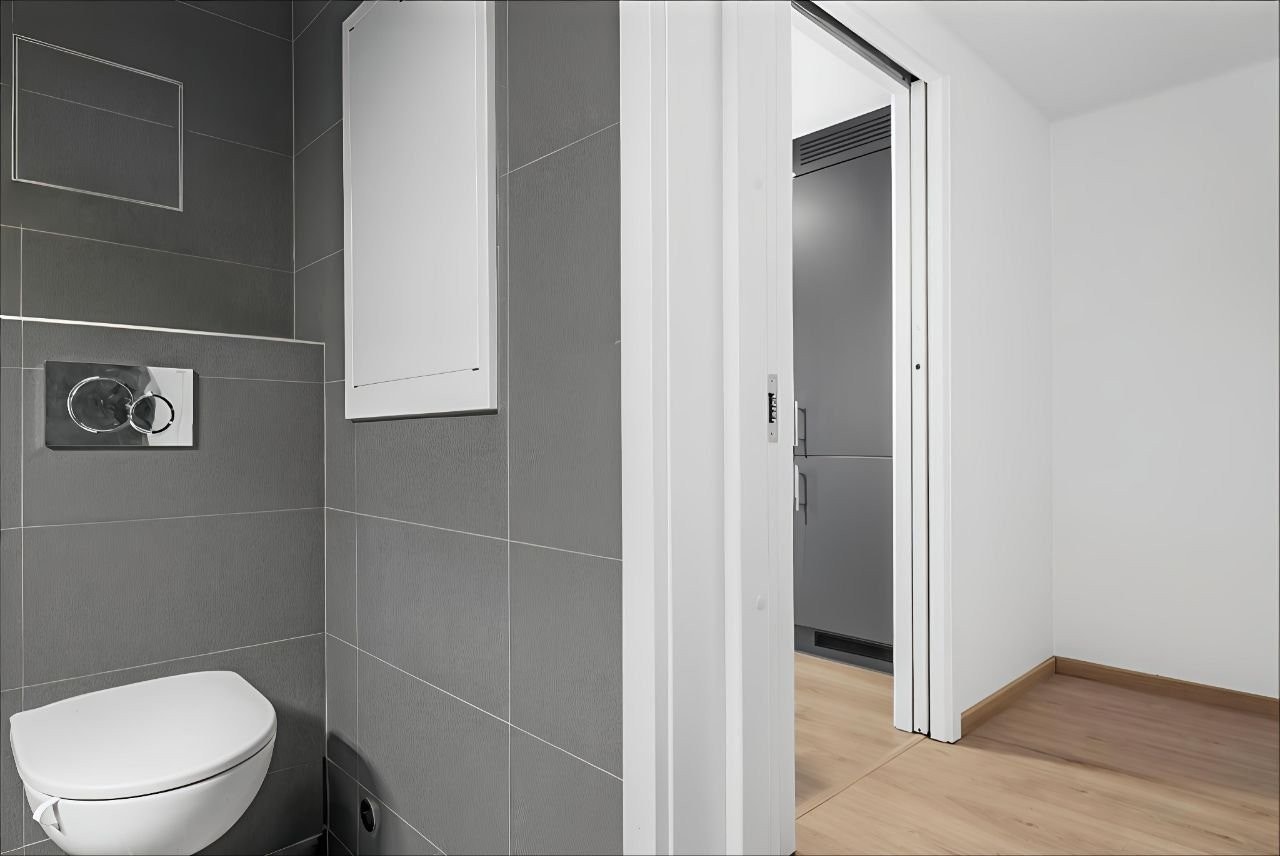 Entré og stilrent bad med flislagte overflater og varmekabler i gulv. Galleribilde