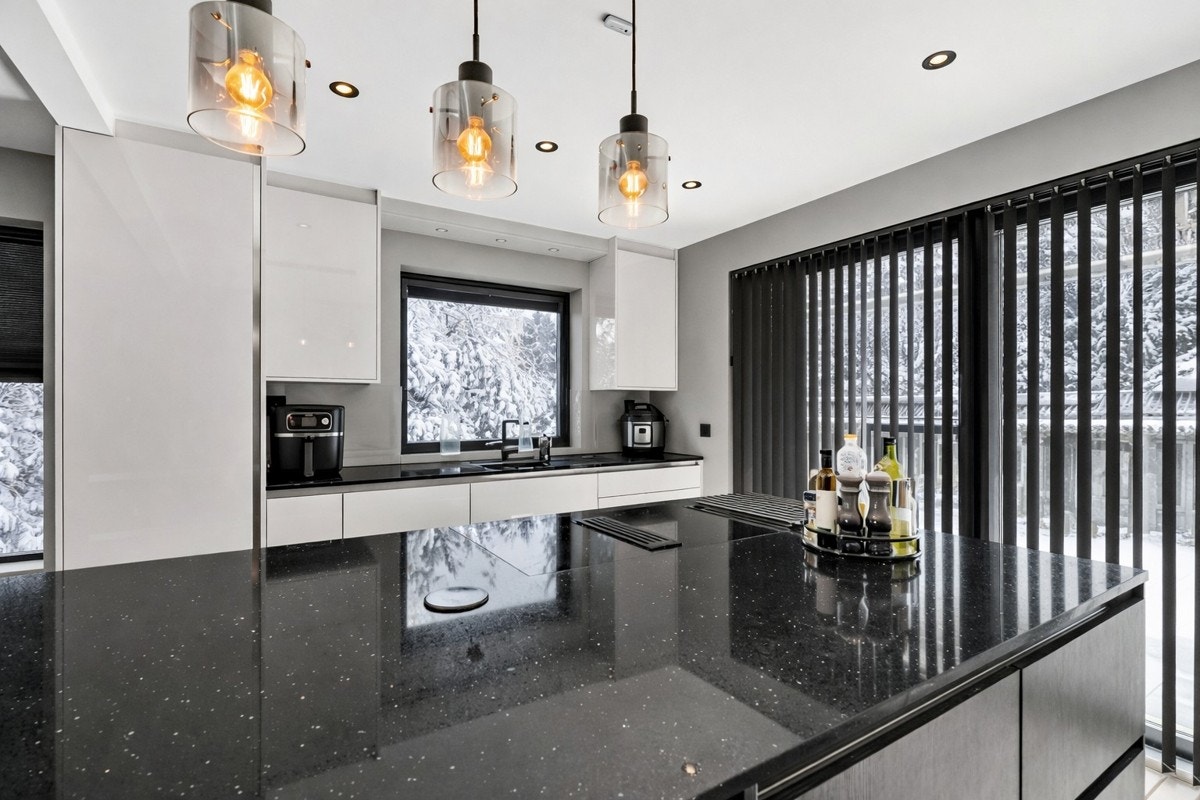 Stilrent og moderne kjøkken med påkostede løsninger, lekker kjøkkenøy med integrert platetopp og rikelig benkeplass. Galleribilde