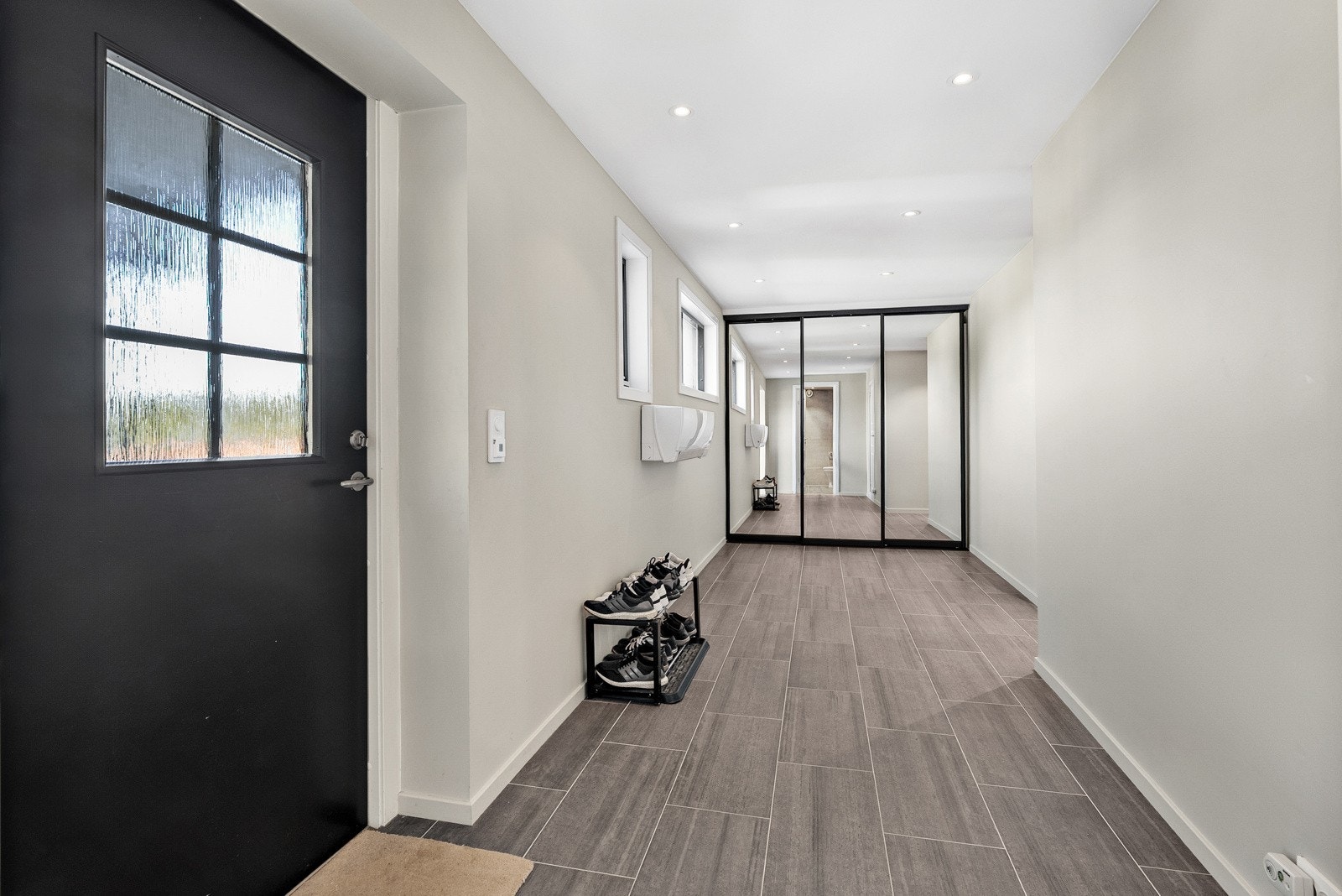 Lys og romslig entré med flislagt gulv, god plass til oppbevaring og praktiske skyvedørsgarderober. Galleribilde