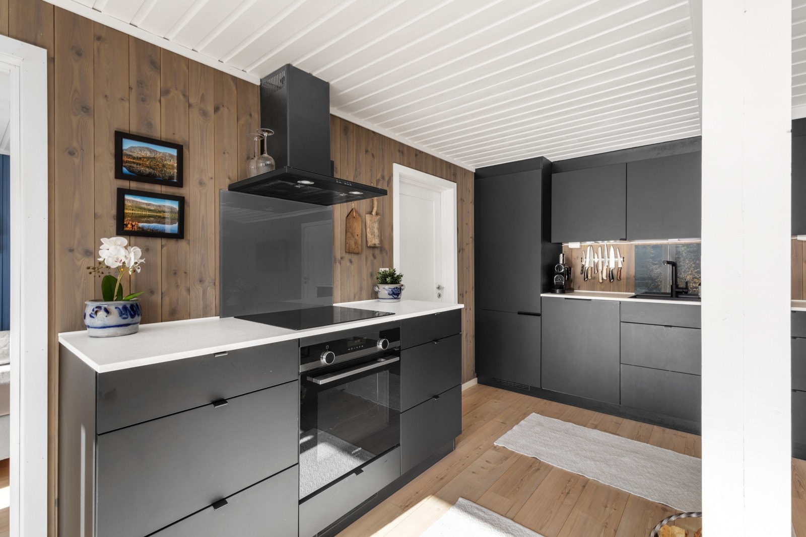 Innredningen har stilrene, slette fronter, benkeplate med vaskekum og ettgreps armatur Galleribilde