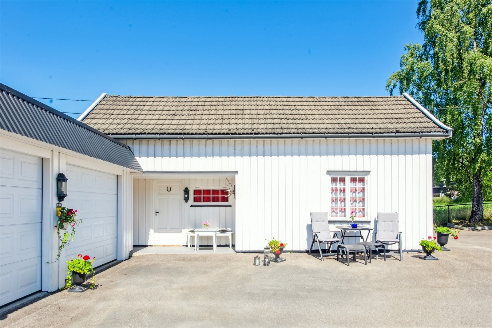 Koselig og solrik uteplass utenfor garasje Galleribilde