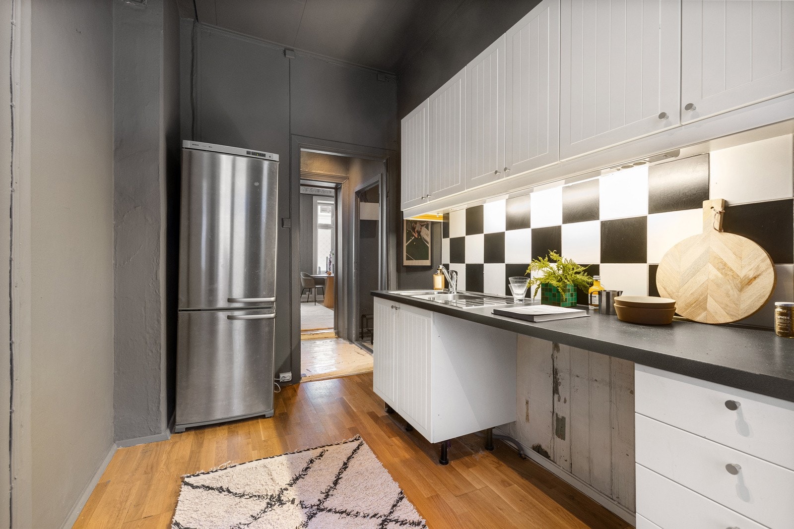 Det er nedfelt oppvaskkum i stål. Kjøkkenet er utstyrt med komfyr og opplegg for oppvaskmaskin og plass til kjøleskap.Over stekesonen er det kullfiltervifte. Galleribilde