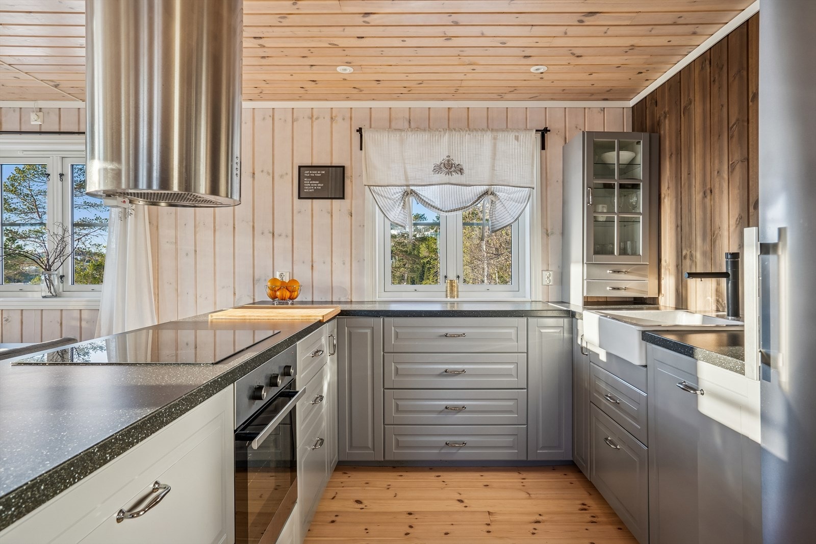 Pent kjøkken som har godt med skap- og benkeplass Galleribilde