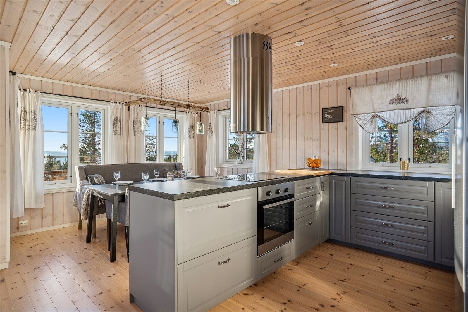 Hytta har en åpen stue kjøkkenløsning som har en naturlig soneinnedeling Galleribilde