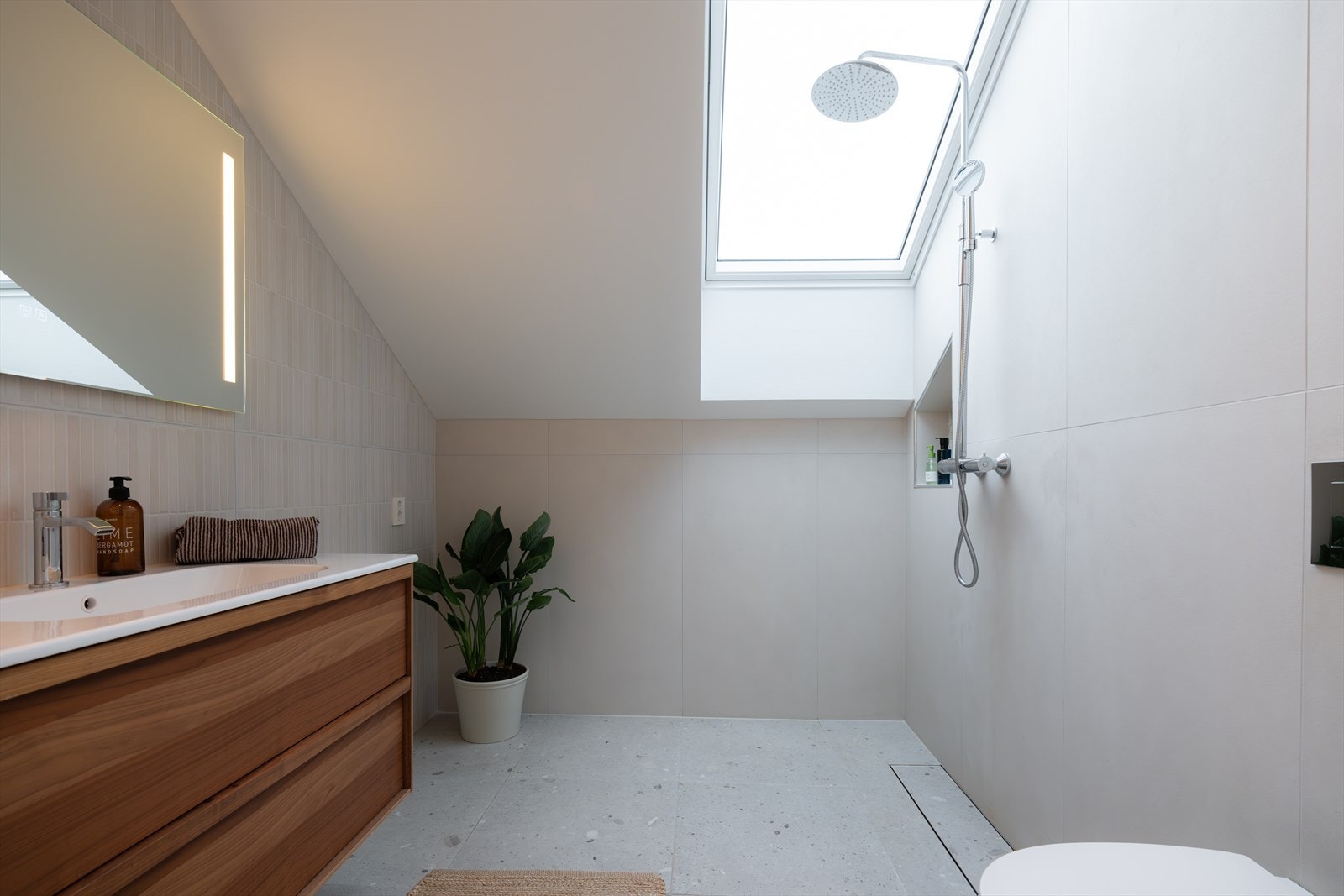 Lekkert, flislagt bad med takvindu i dusjen som tilfører naturlig lys og skaper en unik romfølelse. Her får du følelsen av å dusje med frisk luft og dagslys Galleribilde