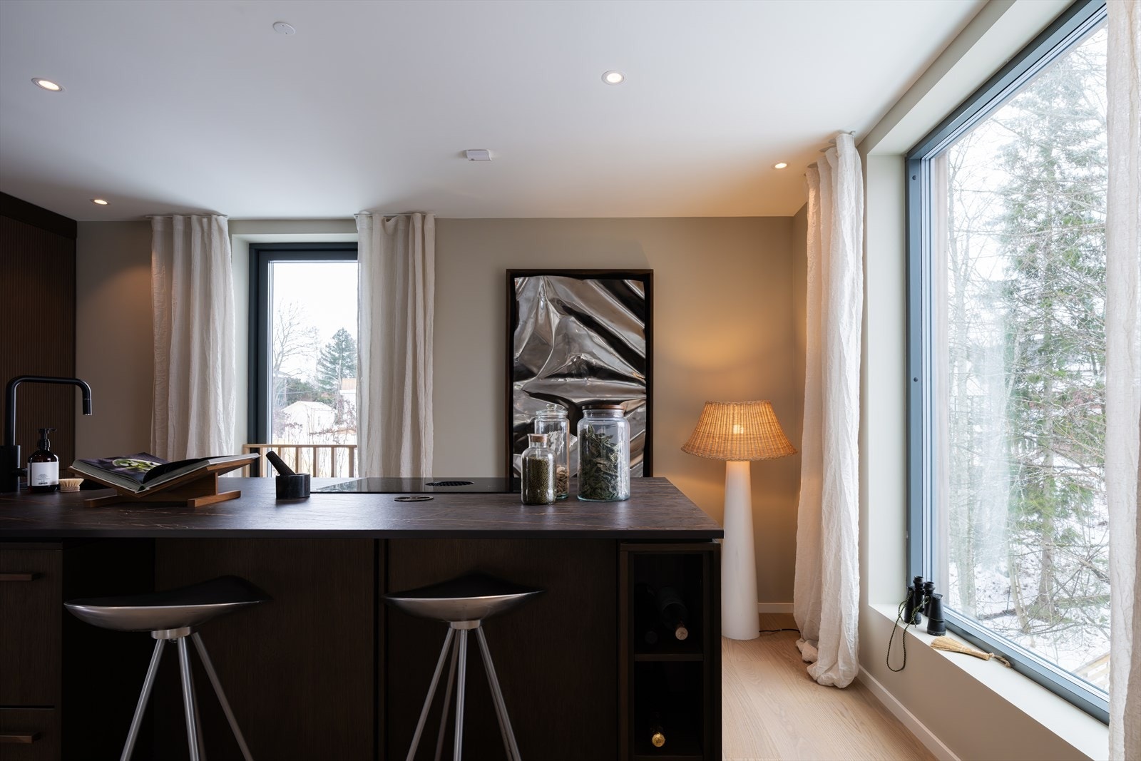 Kjøkkeninnredningen har glatte fronter, belysning i skapene og benkeplate med nedfelt kum Galleribilde