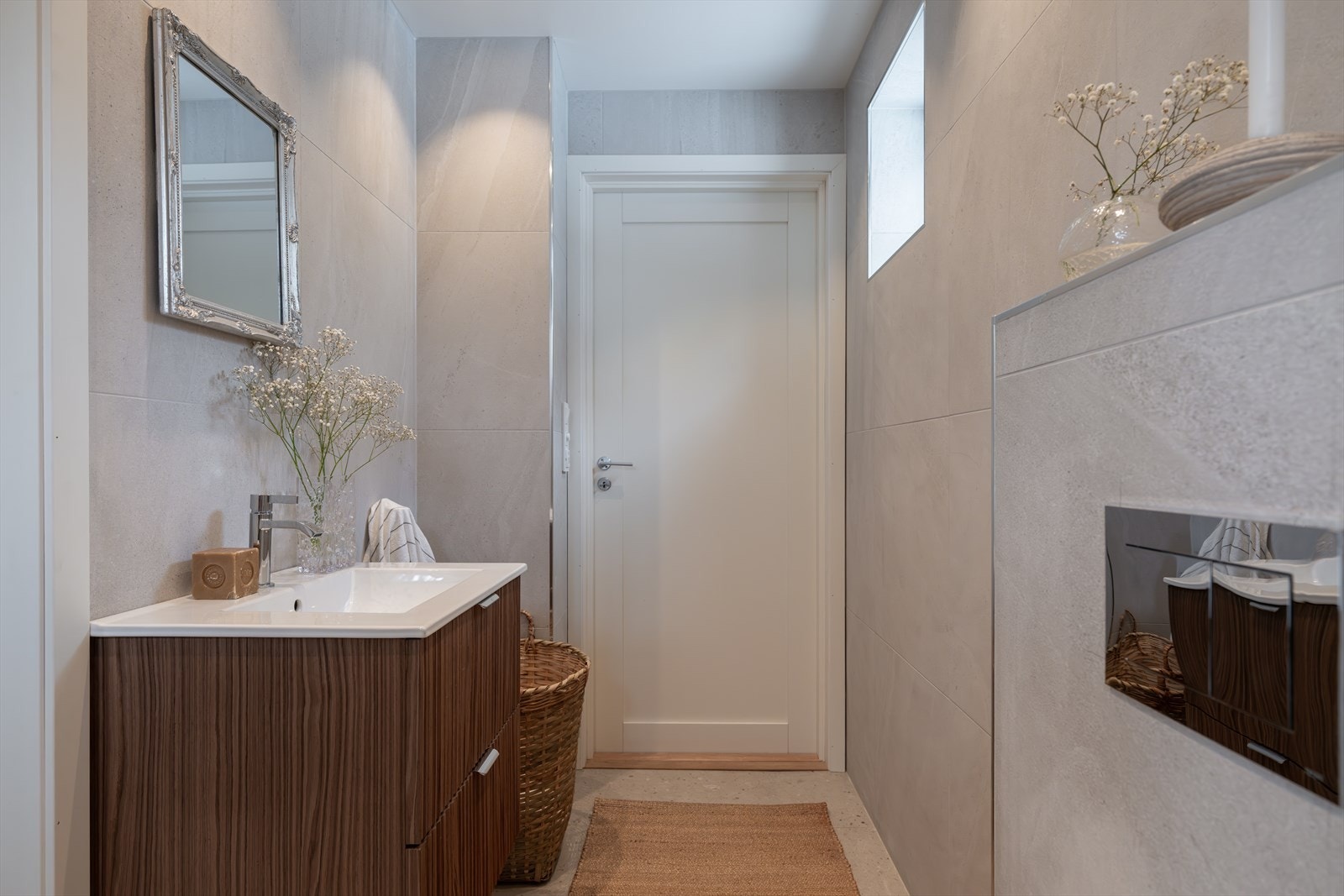 Innredningen består av servant, dusj på gulv og veggfestet toalett med innebygd sisterne Galleribilde