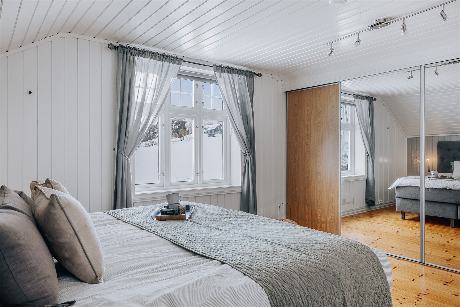 Rikelig med oppbevaringsplass i stor plassbygget skyvedørsgarderobe med to speildører. Galleribilde