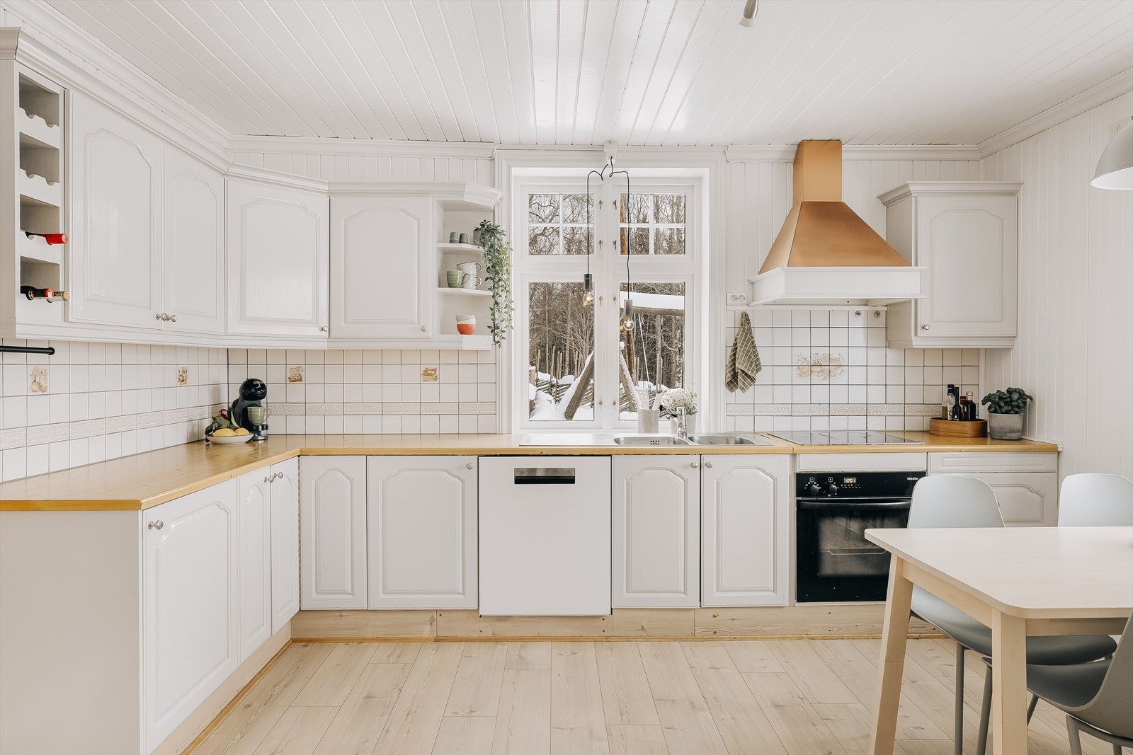 Lys og pen kjøkkeninnredning med masse skap- og benkeplass. Innredningen har lysmalte profilerte fronter og laminert benkeplate med nedfelt oppvaskkum. Galleribilde