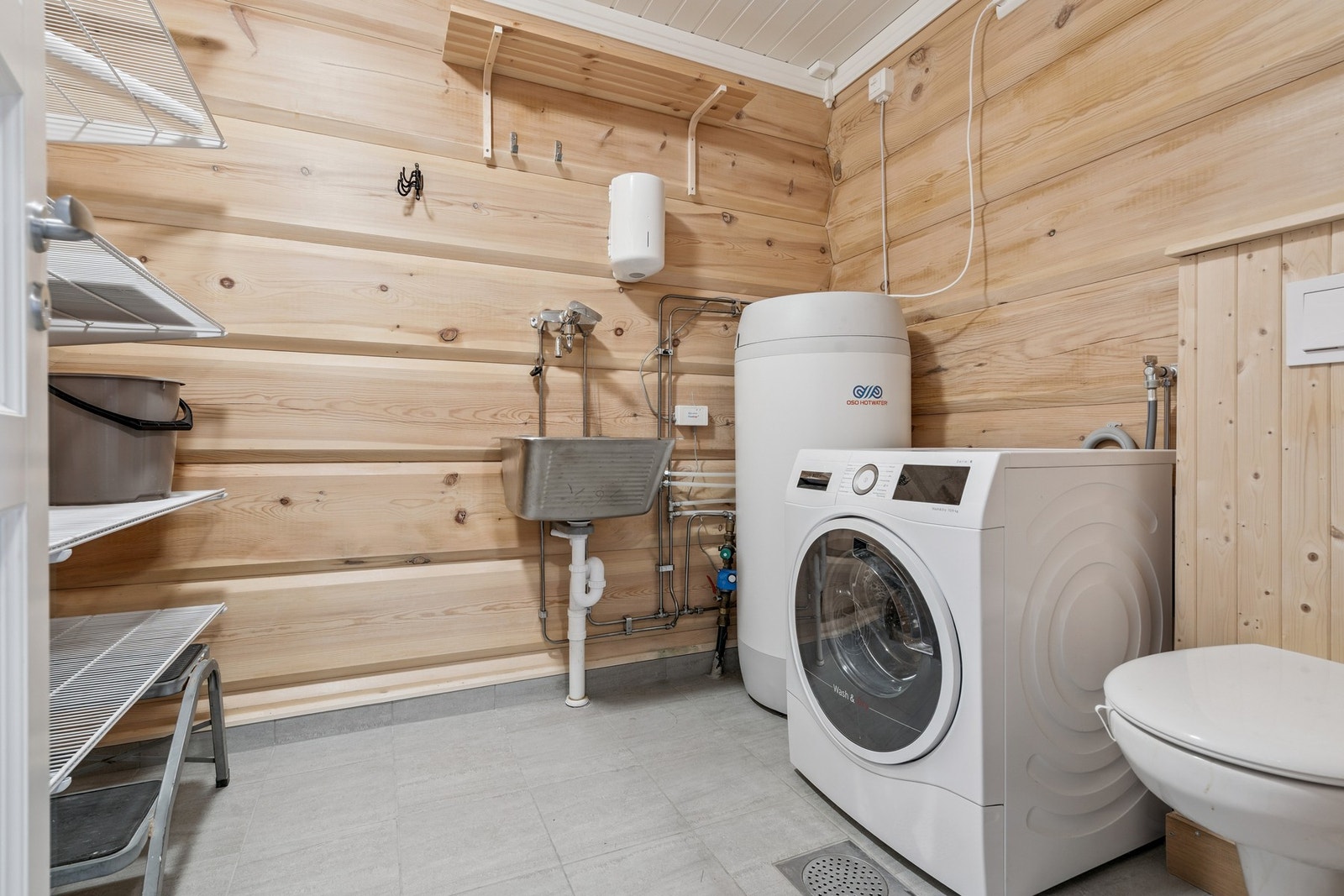 Praktisk vaskerom innredning, opplegg for vaskemaskin og toalett. Galleribilde