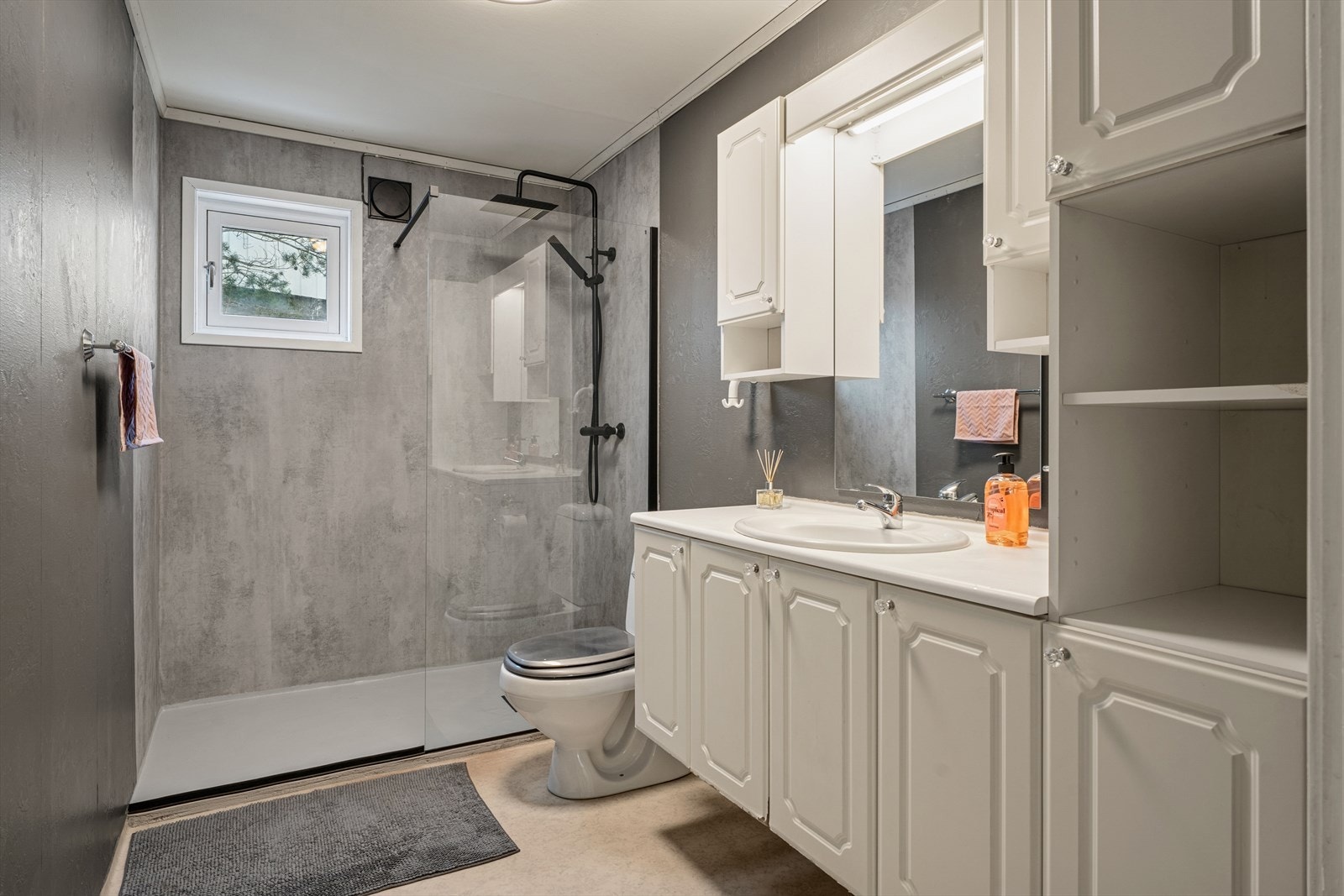 Badet er fra byggeåret. I 2026 ble det støpt ny betongsåle i dusjsonen, med ny dusjvegg og blandebatteri. Mikrosement kontaktplast på veggene i dusjsonen. Galleribilde