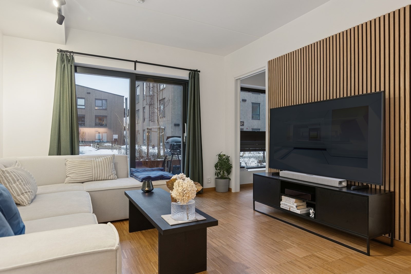 Stue med store vindusflater som slipper inn rikelig med naturlig lys og skaper en varm og inviterende atmosfære. Galleribilde