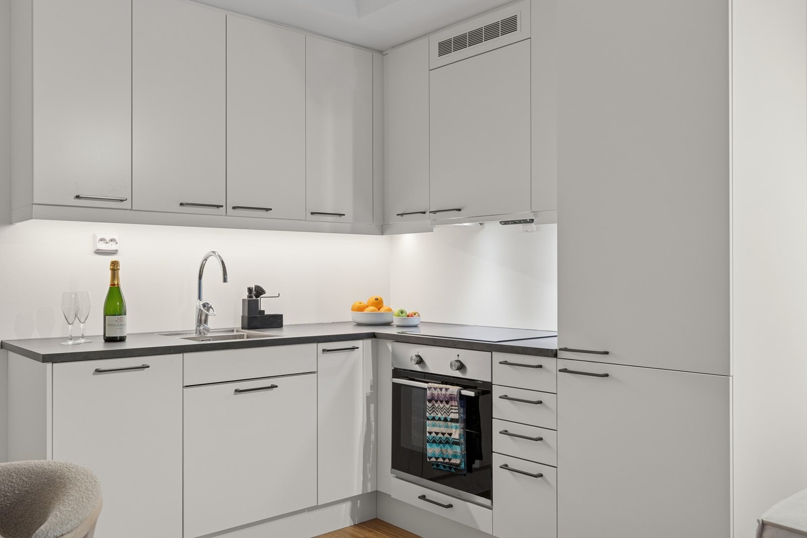 Kjøkkeninnredning med moderne skap med folierte skrog og slette fronter. Her har du god oppbevaringsplass og hvitevarer medfølger. Galleribilde