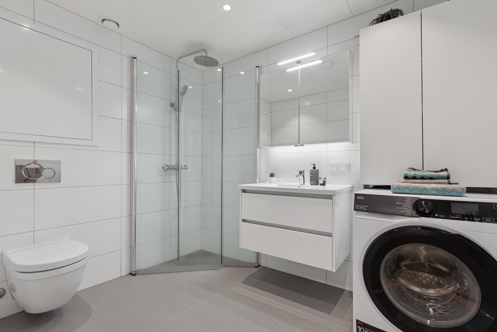 Badet fremstår som stilrent og innbydende, med flislagte gulv og vegger som gir et helhetlig og moderne uttrykk. Galleribilde