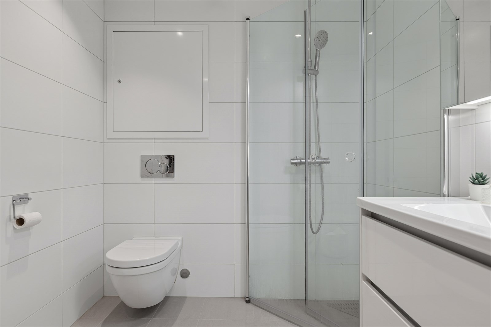 Utstyrt med dusjvegger i glass og moderne dusjgarnityr samt vegghengt toalett som gir en luftig og lettstelt løsning. Galleribilde