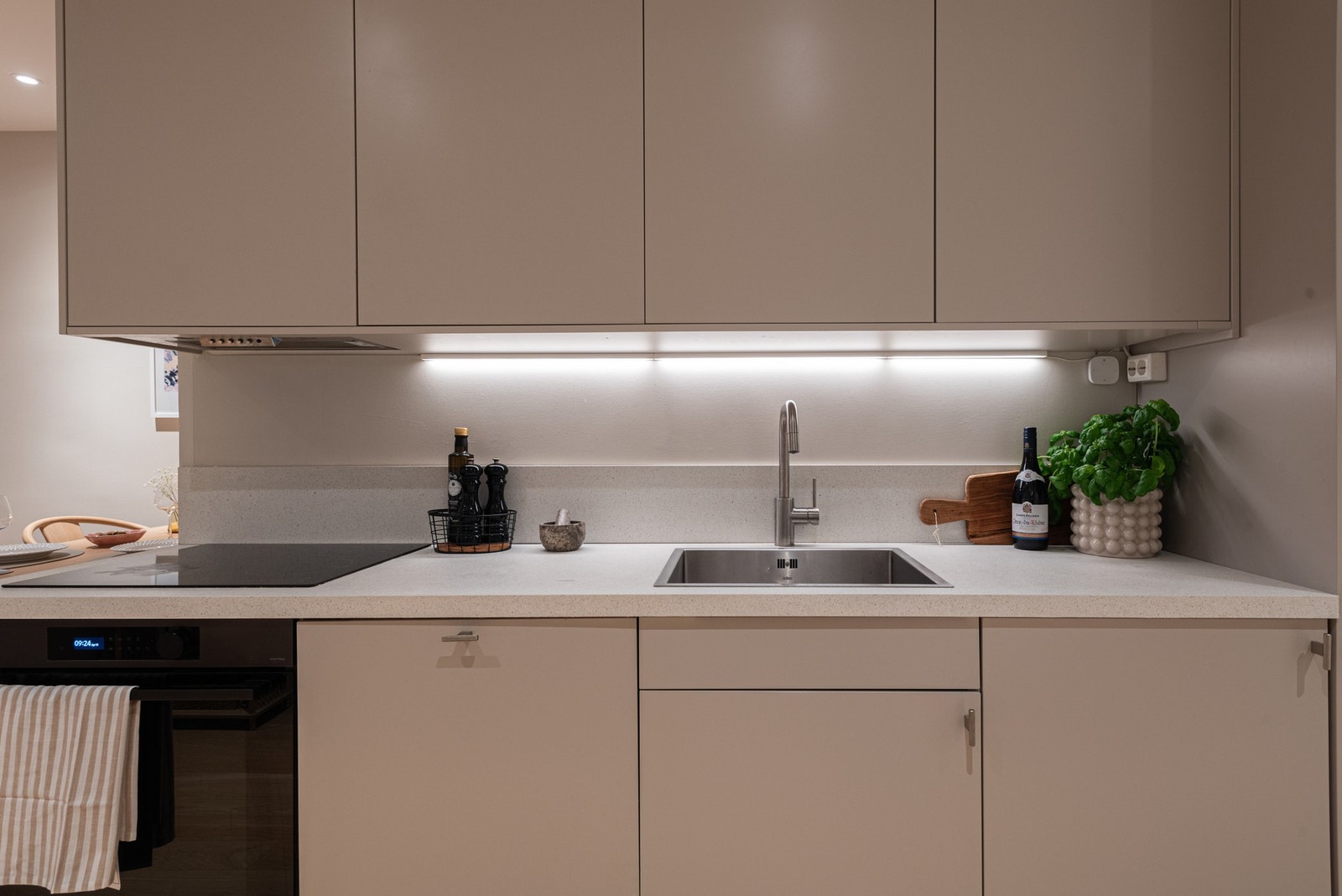 Videre har kjøkkenet ventilator over platetopp, nedfelt oppvaskkum og opplegg for vaskemaskin. Galleribilde