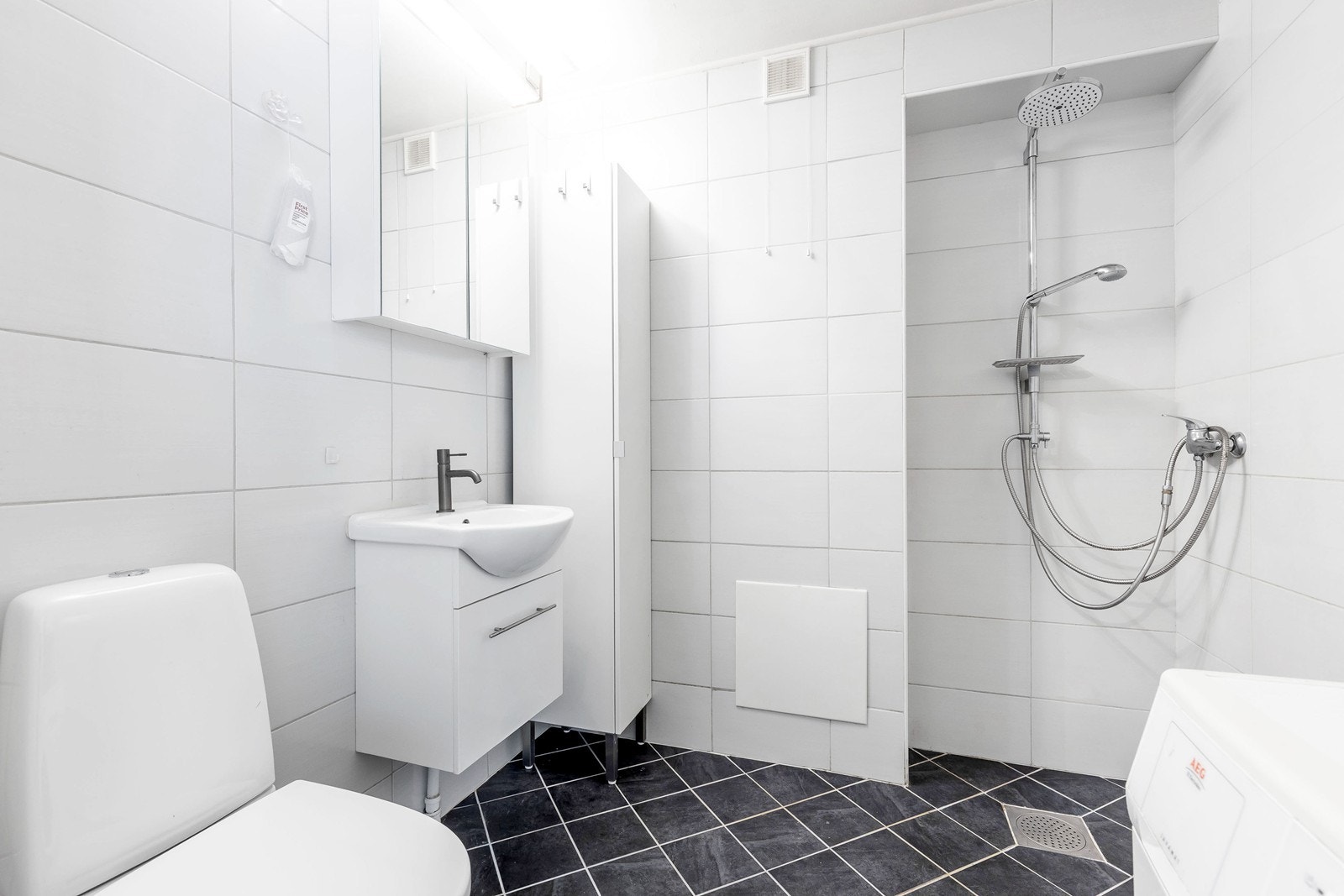 Flislagt bad med dusjhjørne. Badet har også opplegg til vaskemaskin. Galleribilde