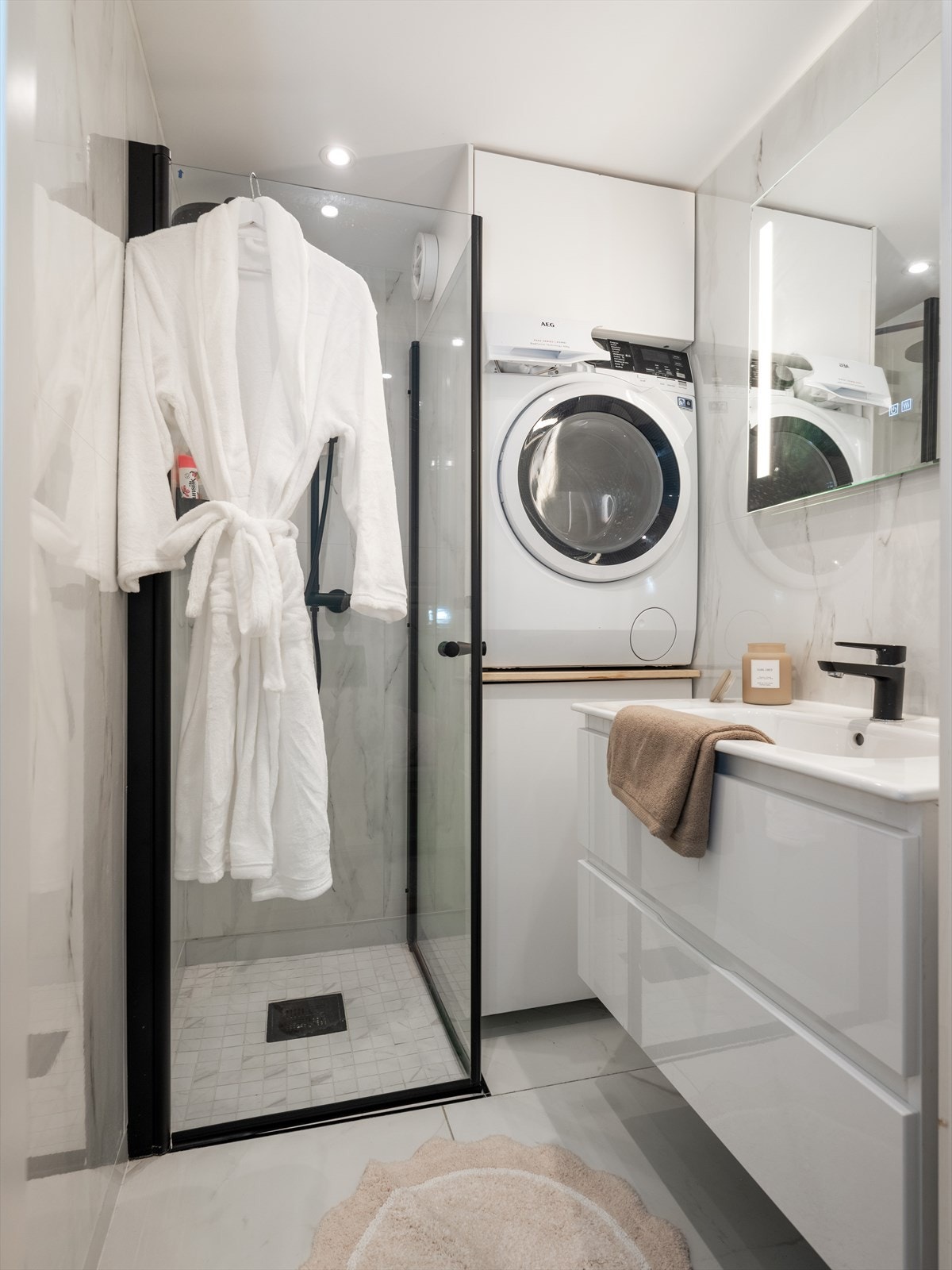 Moderne bad fra 2023 med opplegg for vaskemaskin og tørketrommel. Galleribilde