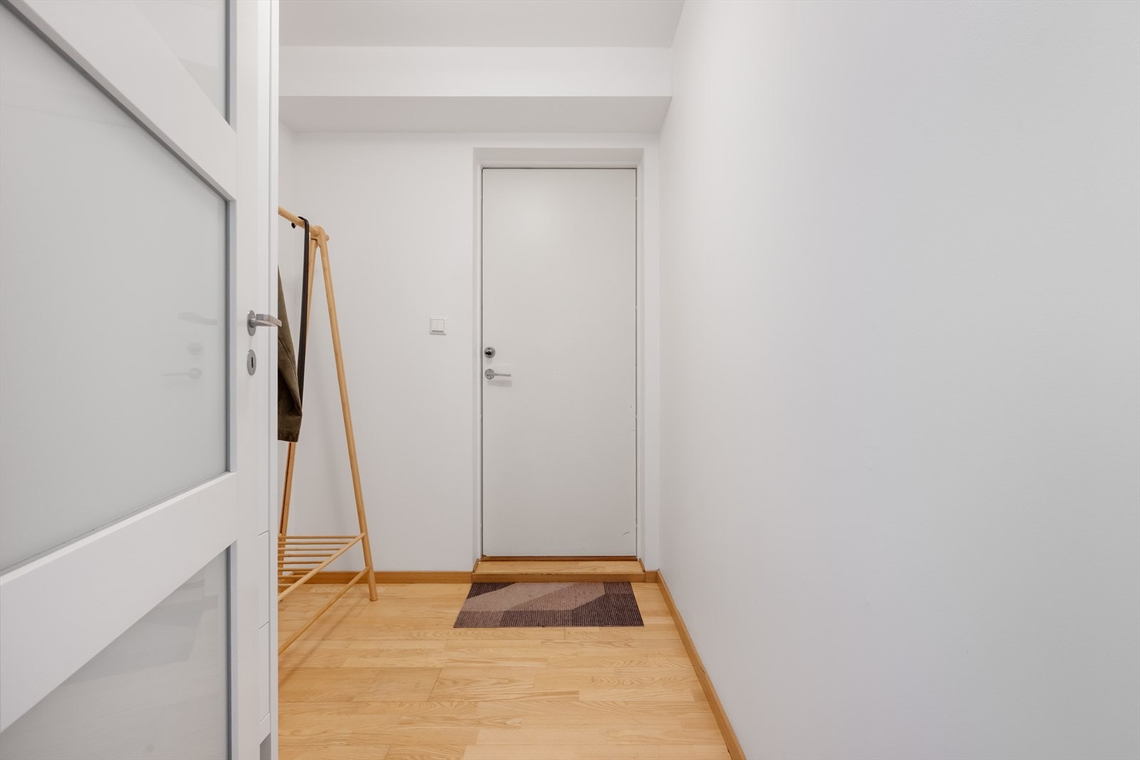 Velkommen inn! Du blir møtt av en lys gang med plass til å henge fra deg ytterøy. Galleribilde