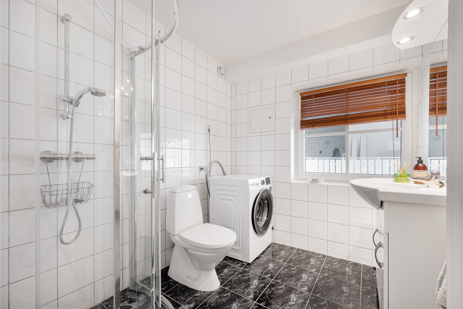 Badet har opplegg for vaskemaskin, nedfelt servant, dusjhjørnet og toalett. Galleribilde