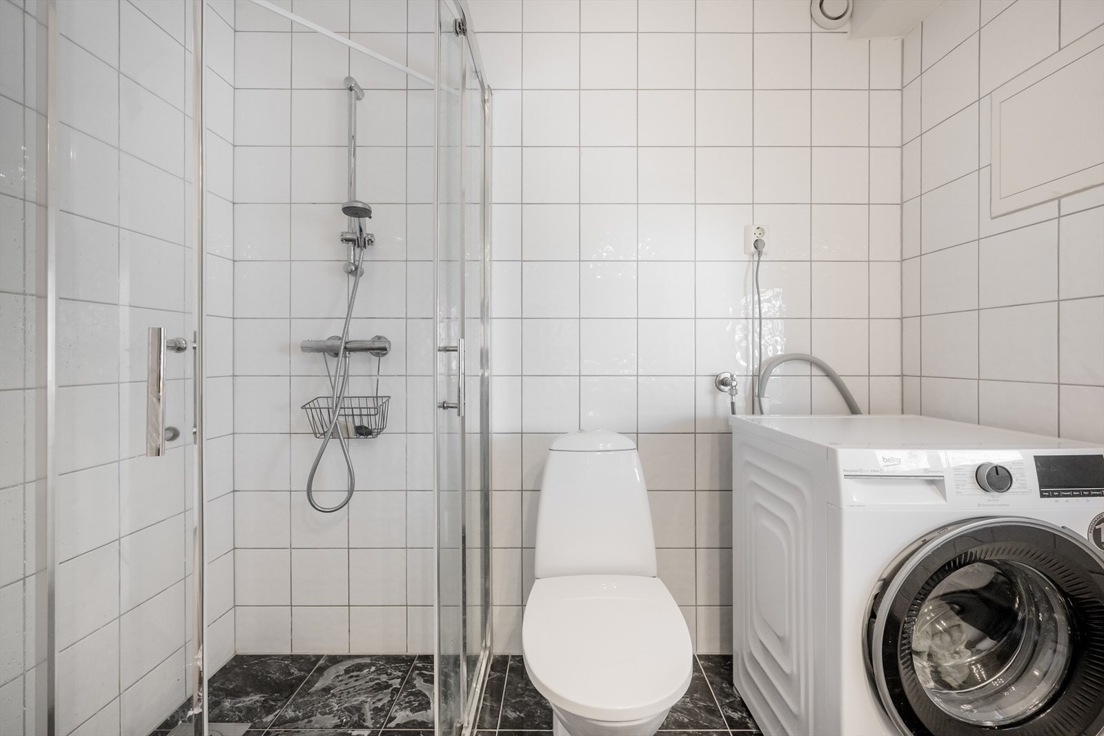 Leilighetens bad med flis på gulv og vegger. Galleribilde