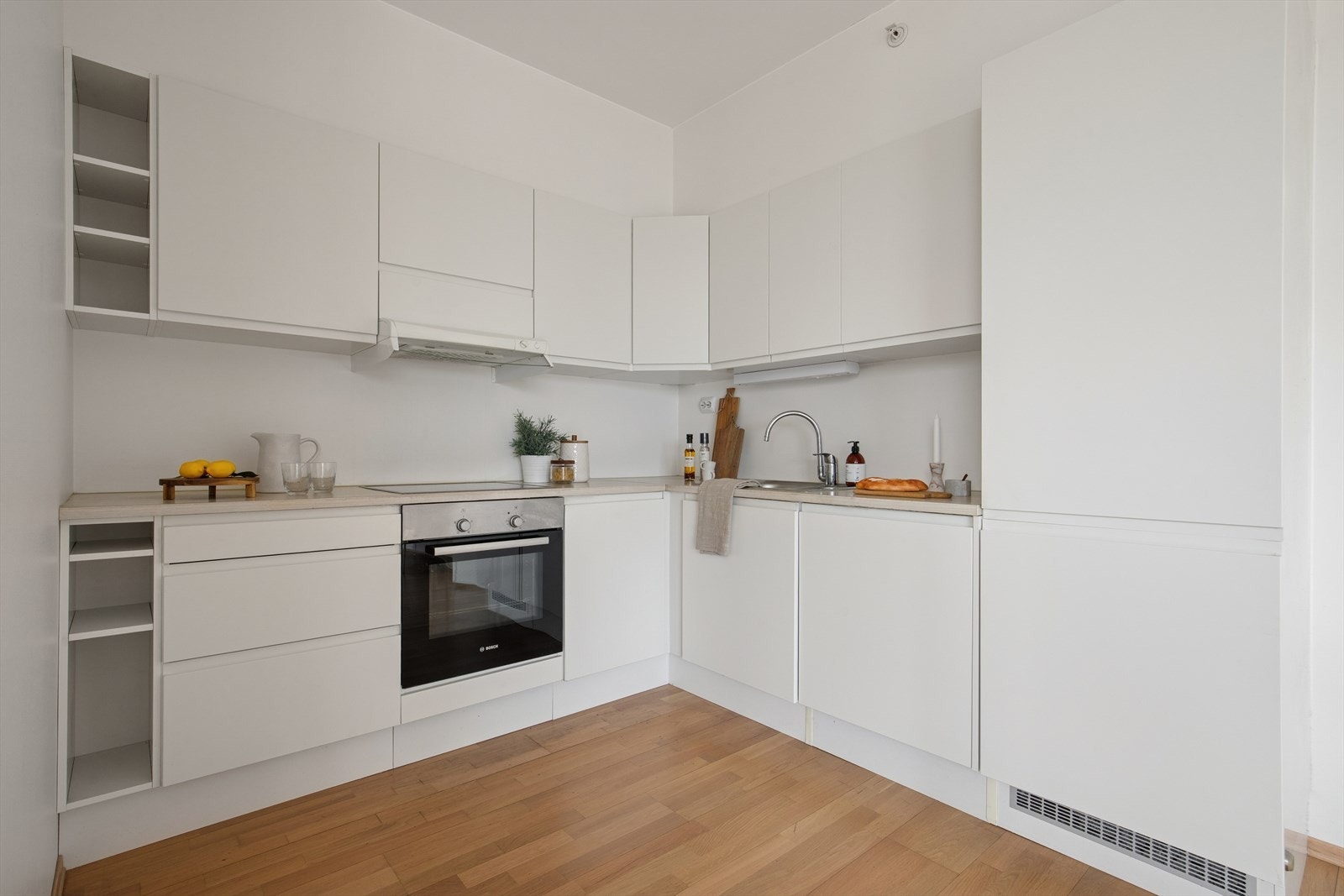 Kjøkkenet er stilrent innredet med hvite, slette fronter og lys benkeplate i laminat. Et godt utnyttet kjøkken hvor man har godt med lagringsplass i skap og skuffer, samt gode arbeidsflater på benk. Galleribilde