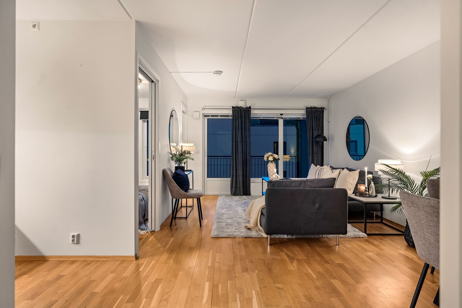 I front får stuen mye naturlig lys fra en stor vindusflate, inkludert en glassdør til den overbygde balkongen. Galleribilde